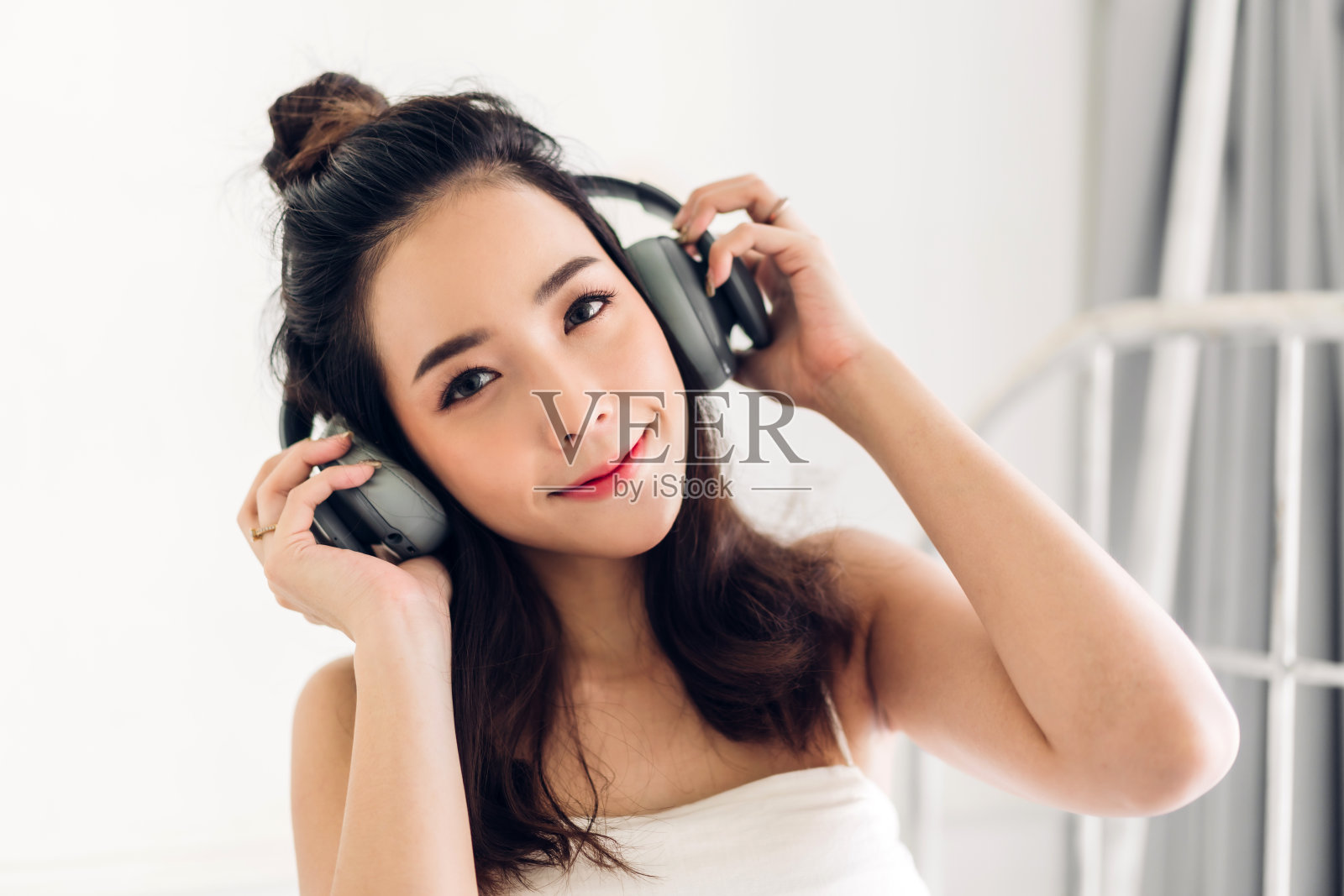 年轻漂亮的亚洲女子在家放松地听音乐照片摄影图片