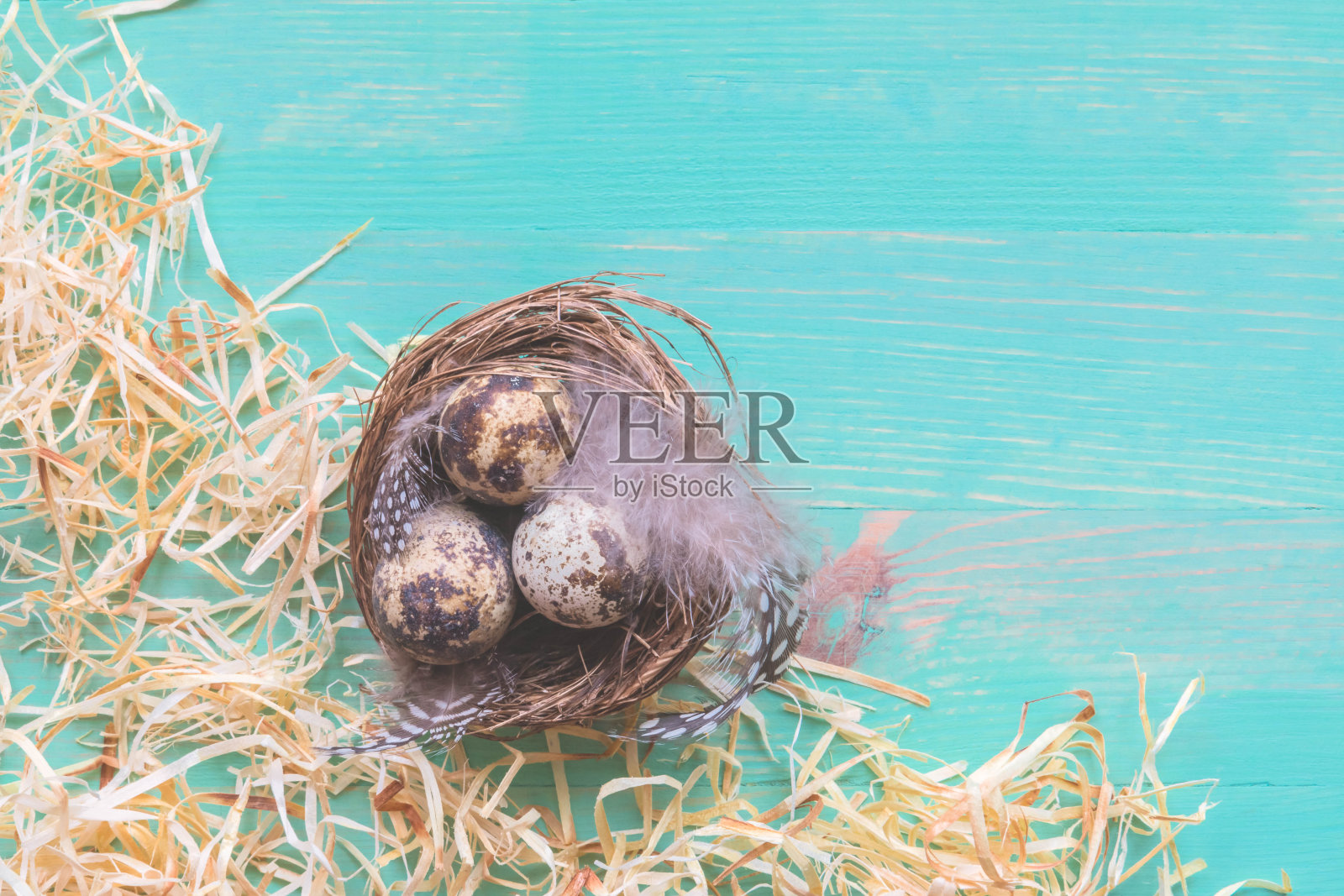在复古的木质背景上，用复活节彩蛋和干草做窝照片摄影图片
