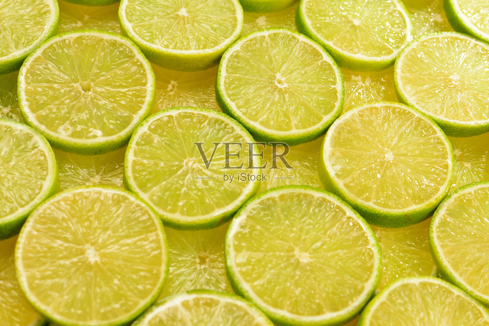 新鲜的酸橙片作为背景。照片摄影图片