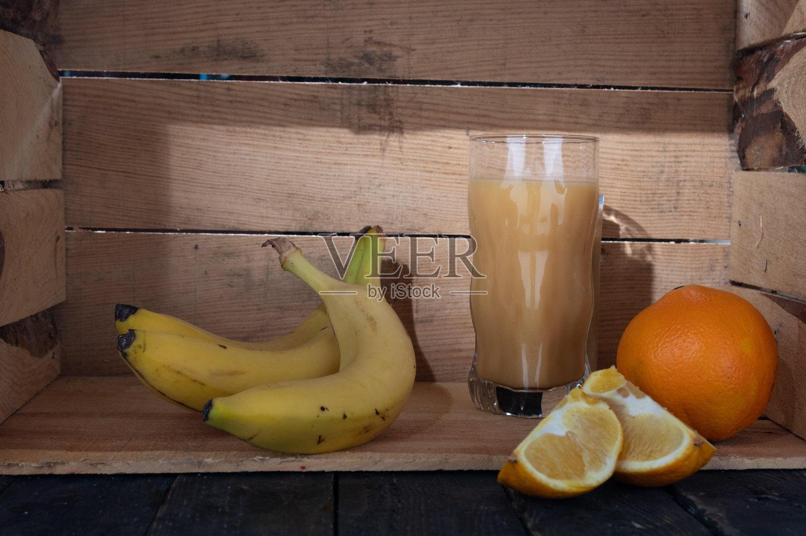 从香蕉和橙子中提取的维生素汁。新鲜维生素果汁。照片摄影图片