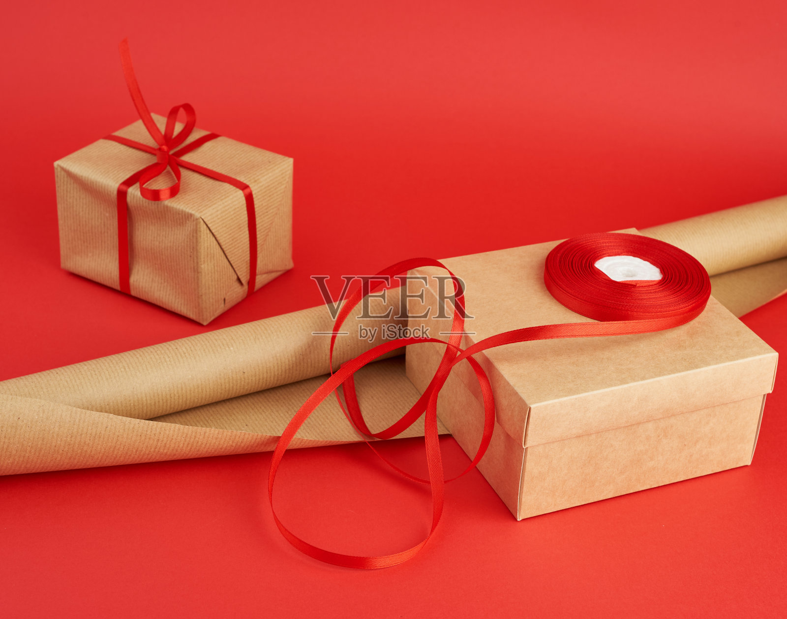 包装用的一卷牛皮纸，一卷红丝带照片摄影图片