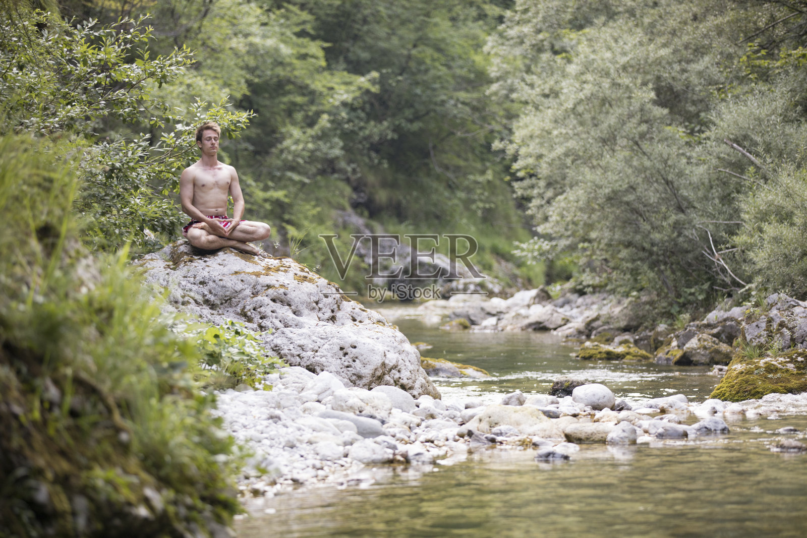 在河边沉思的年轻人照片摄影图片