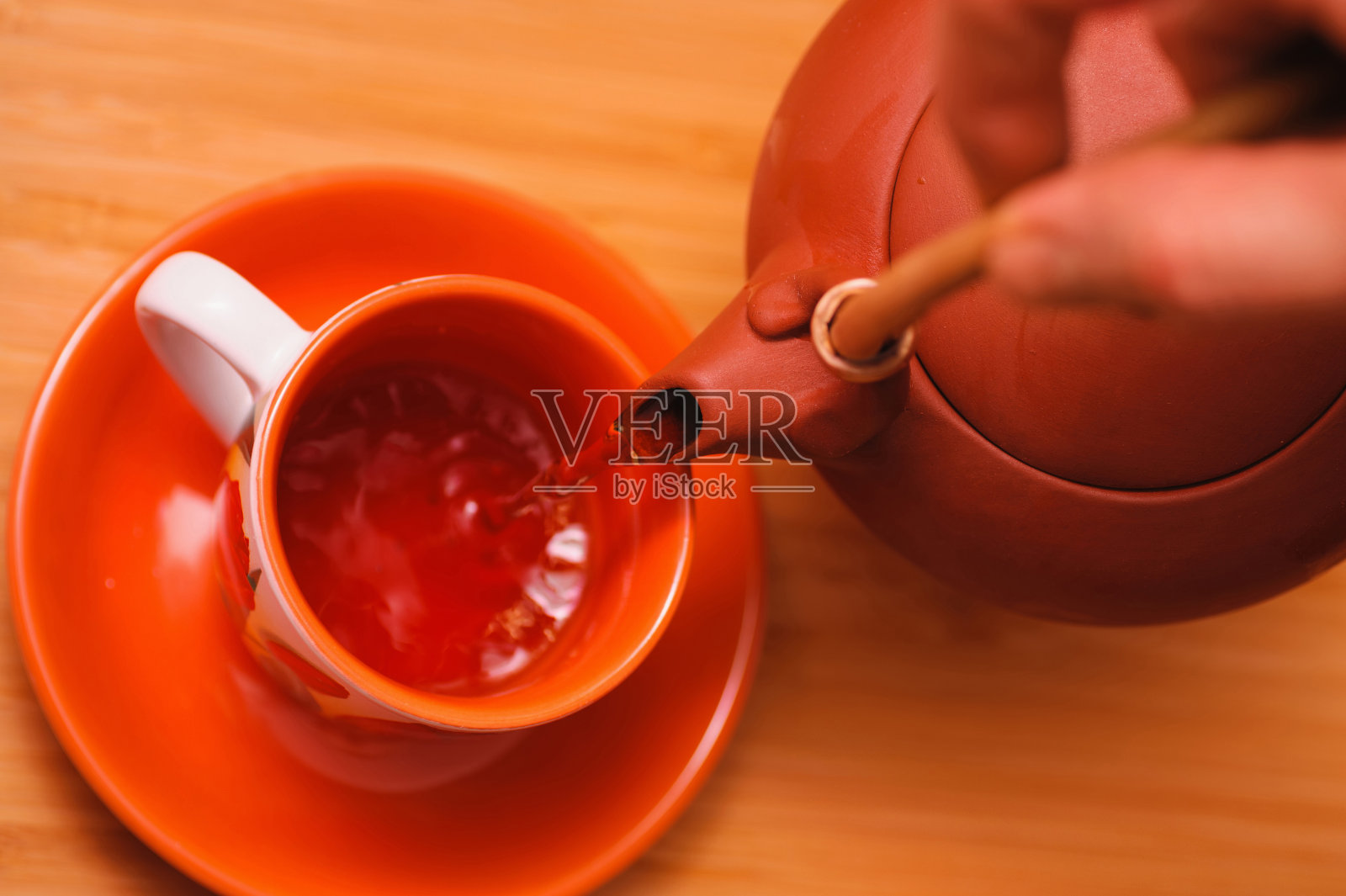 把茶从茶壶倒进杯子里照片摄影图片