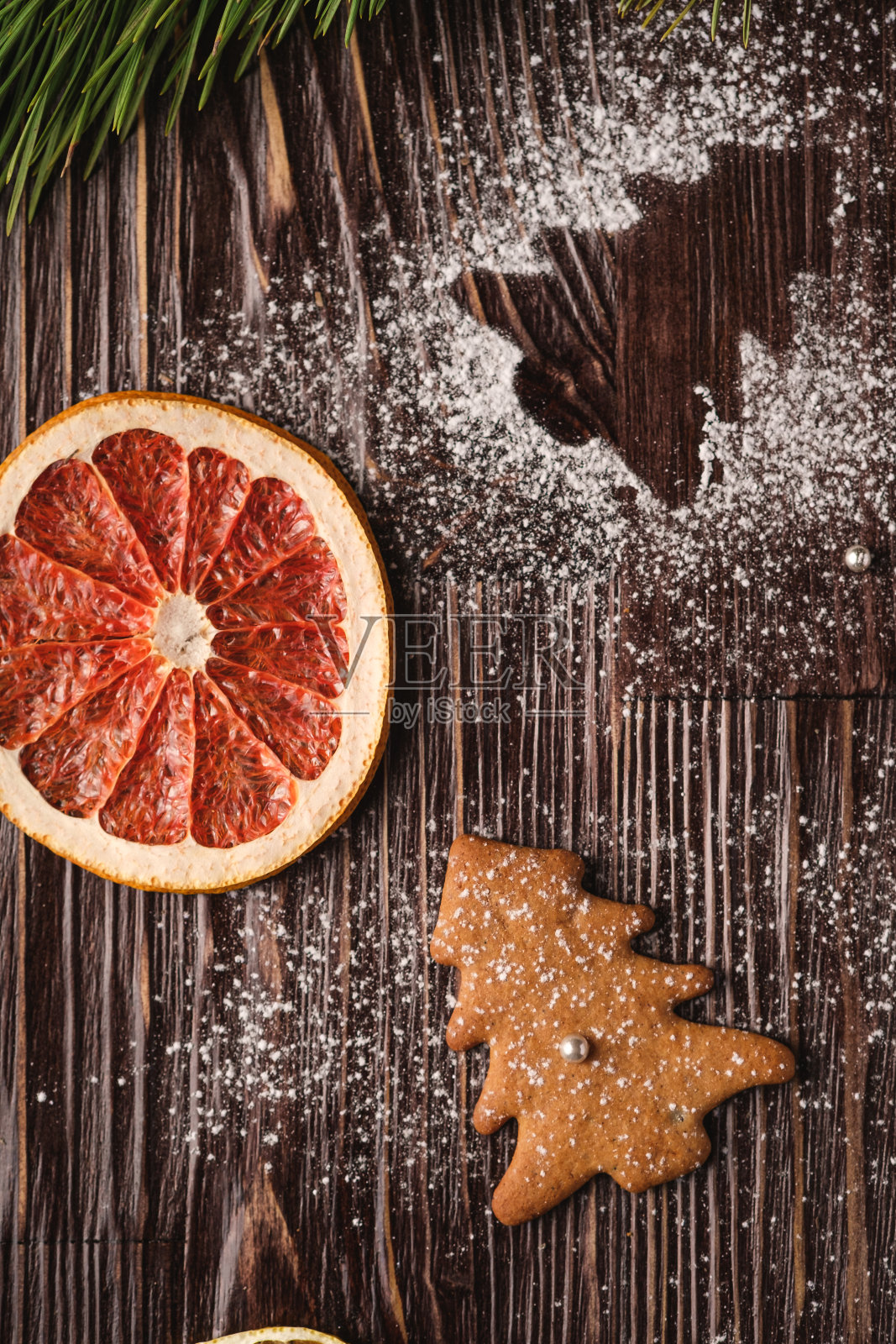 姜饼饼干在圣诞冷杉树，糖粉在木制背景，柑橘干柚子，冷杉树枝，俯视图照片摄影图片