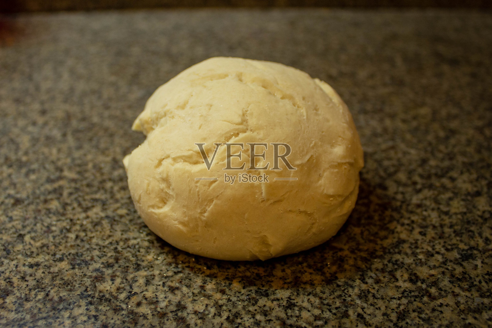 一个新鲜的披萨面团放在厨房的大理石长凳上照片摄影图片