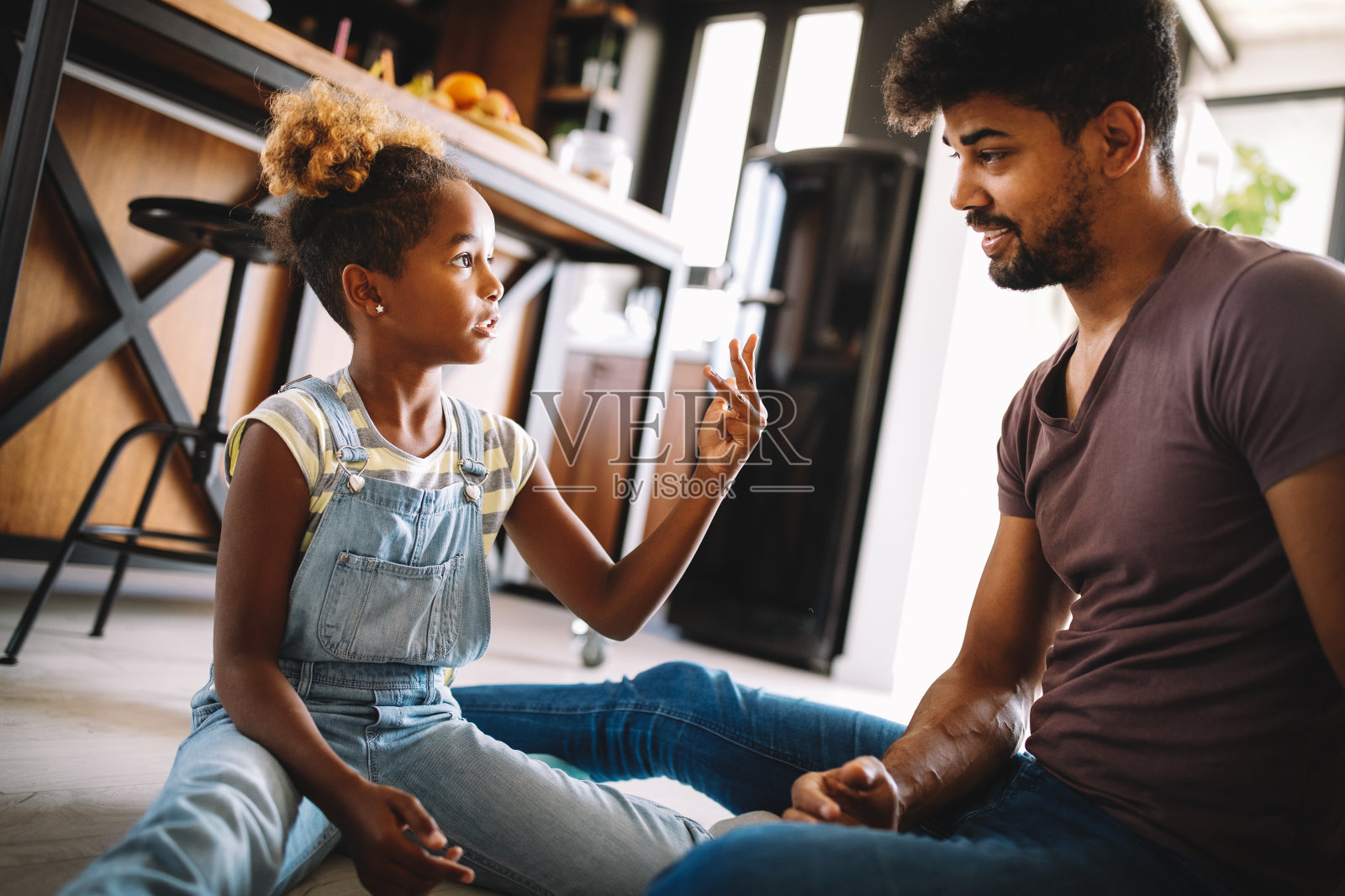 可爱的非洲女孩和她英俊的父亲在家里聊天和微笑照片摄影图片