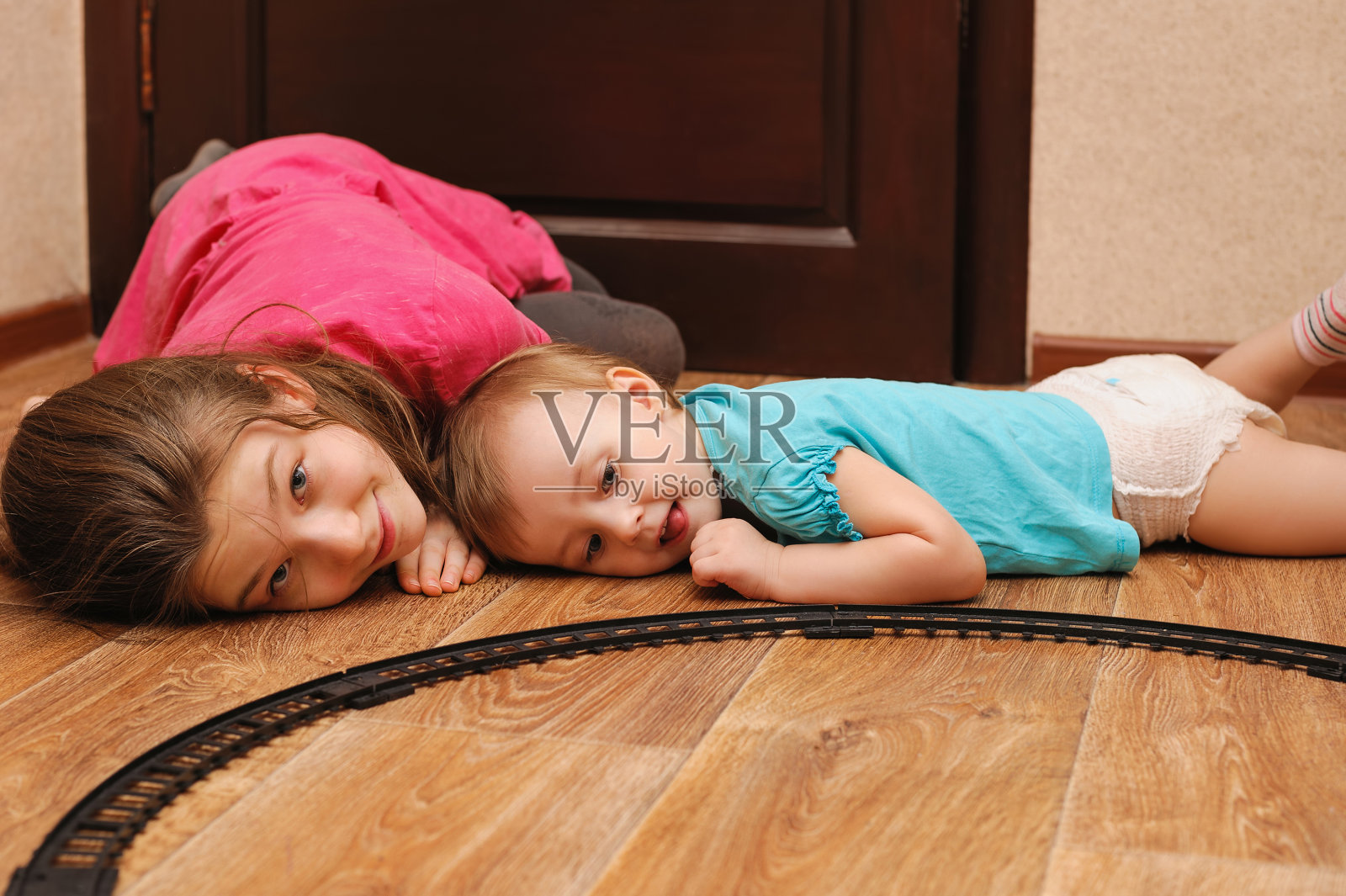 儿童在地板上玩玩具火车照片摄影图片