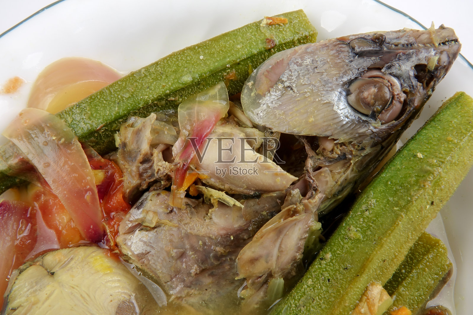 泰国食物冬荫海鱼，金枪鱼辛辣汤在碗上的白色背景。照片摄影图片