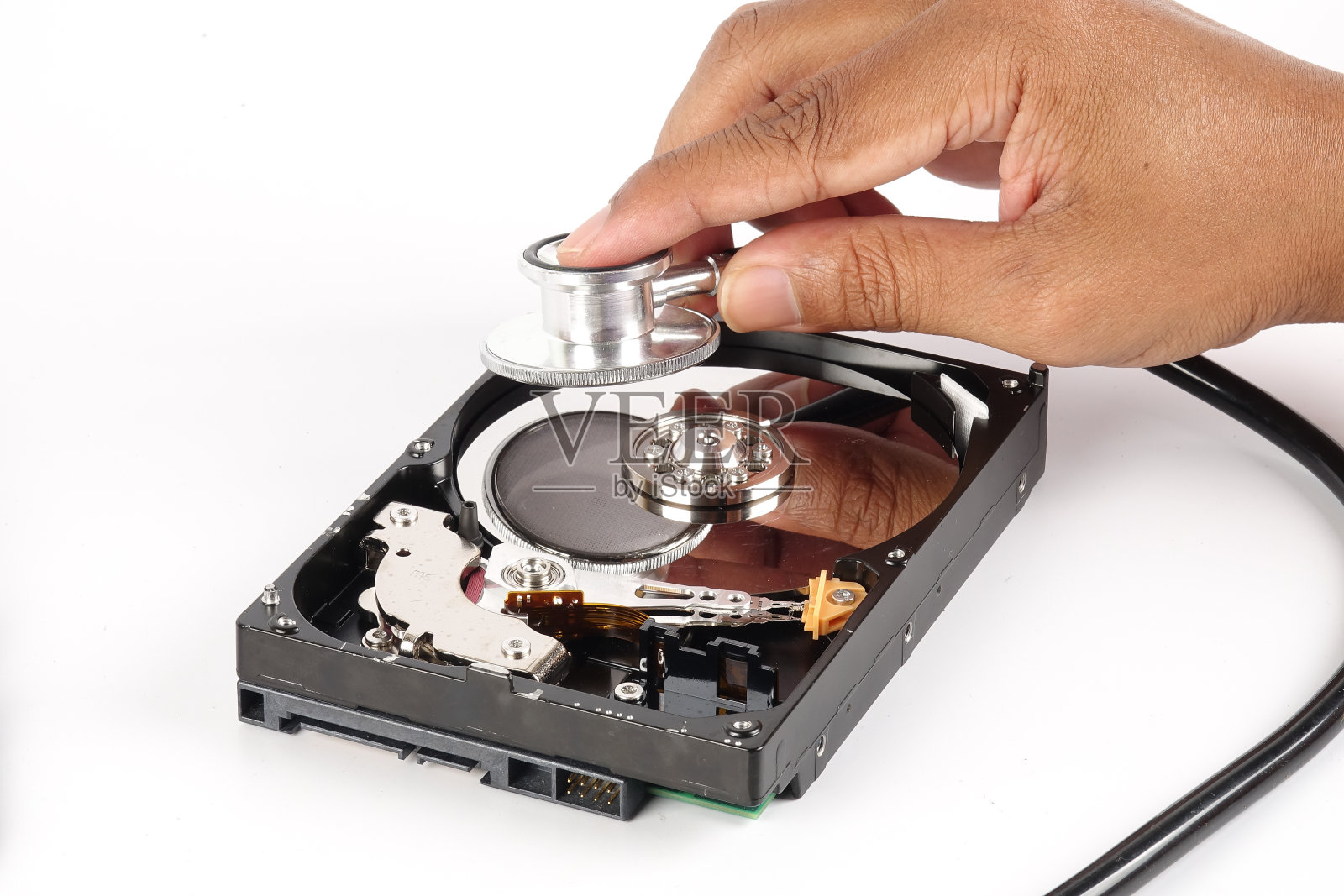 恢复和修复技术概念:硬盘驱动器(HDD)与听诊器隔离在白色。照片摄影图片