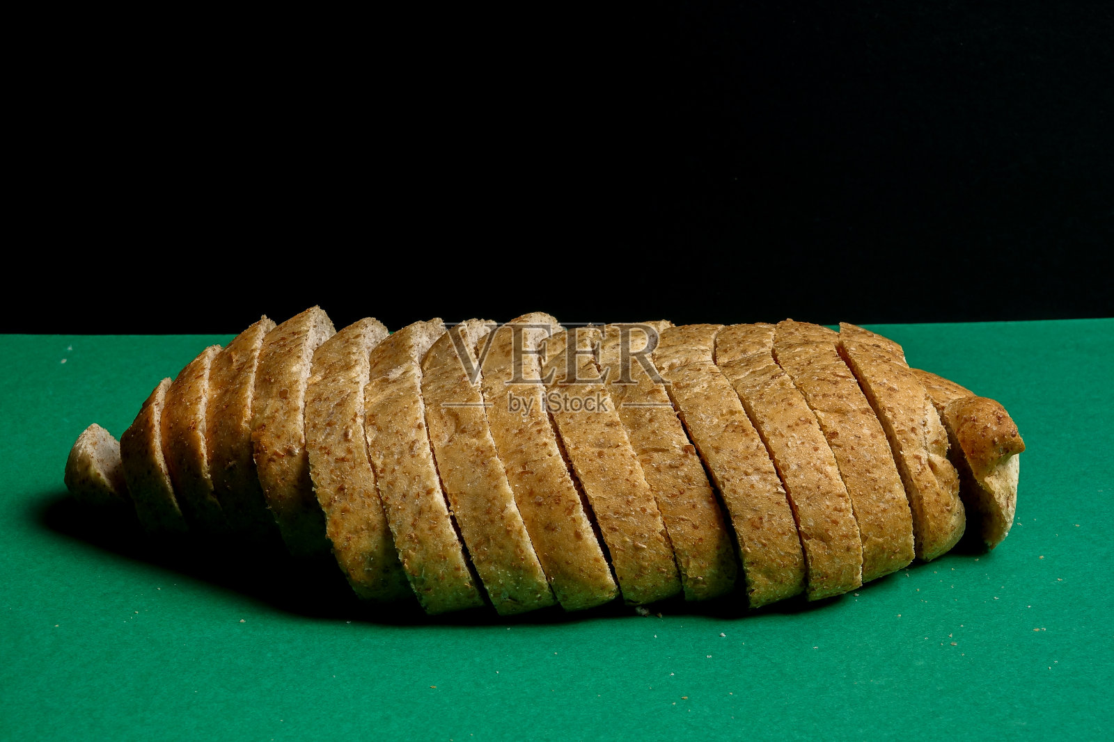 绿色背景上的一条全麦面包照片摄影图片