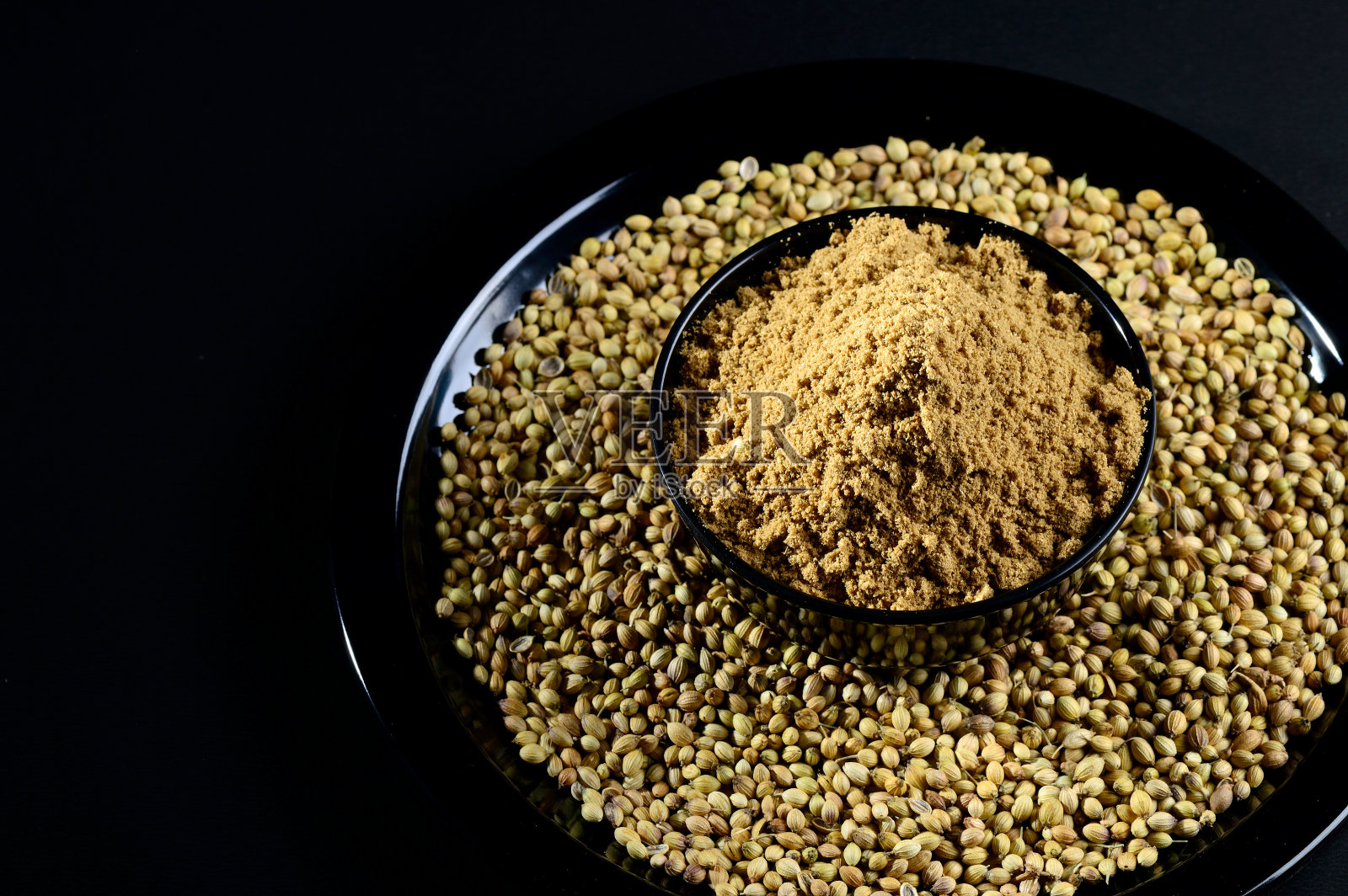 香菜种子和粉末在黑色背景照片摄影图片