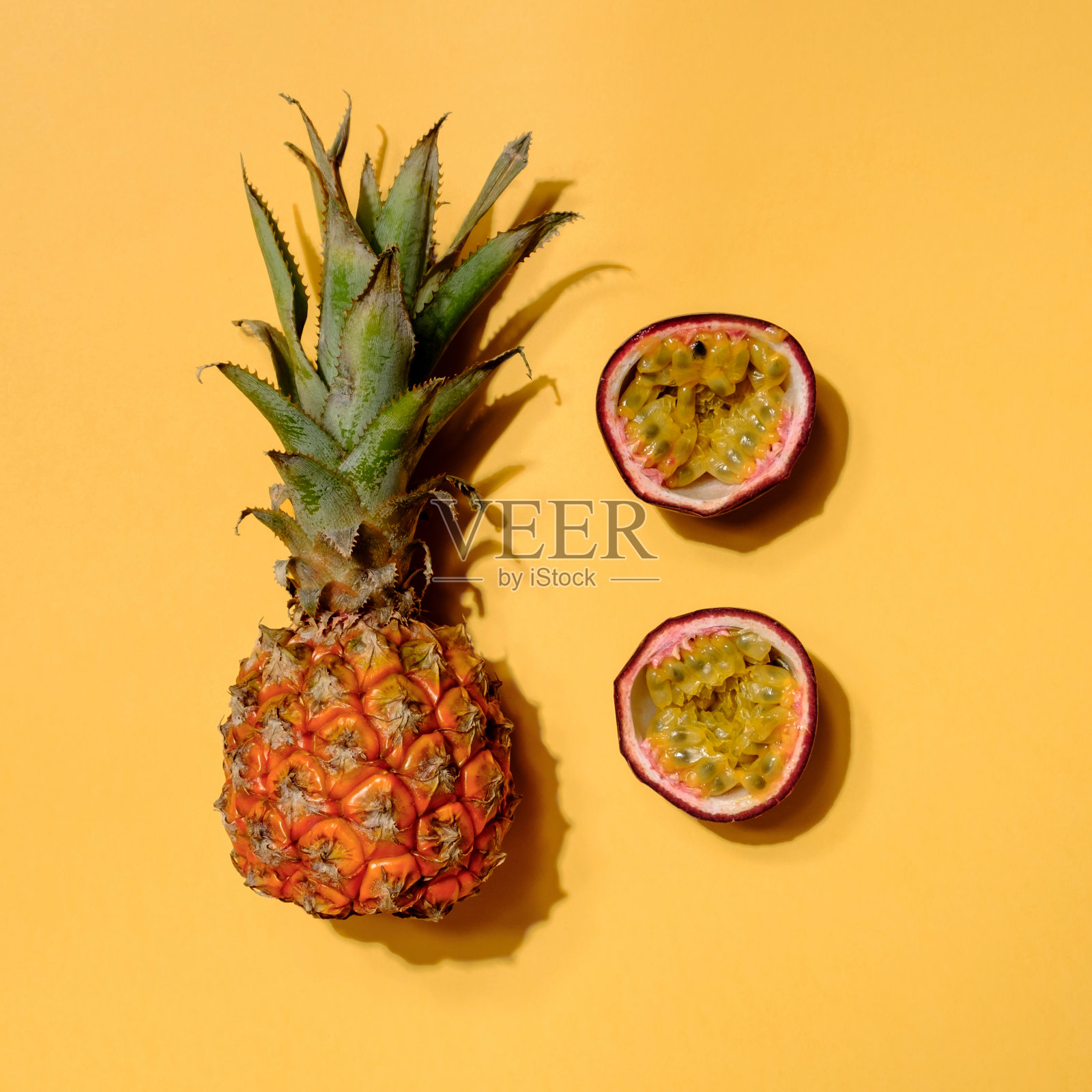 菠萝和百香果的创意布局。平的。食品的概念。五颜六色的水果图案。照片摄影图片