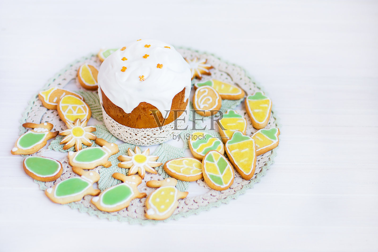 桌上有自制的复活节蛋糕和彩绘饼干。照片摄影图片