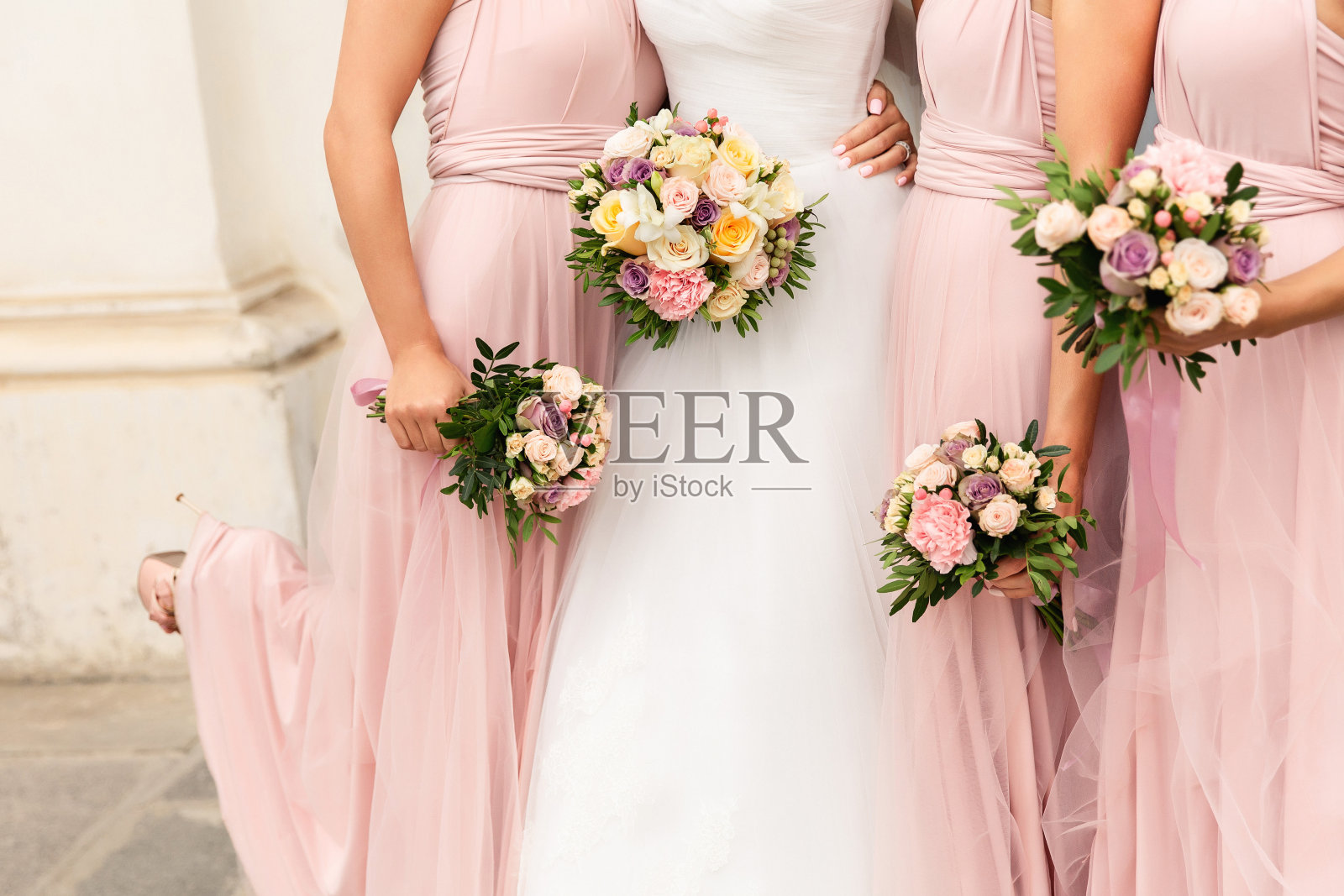 婚礼当天，新娘和伴娘穿着粉红色连衣裙玩得很开心。幸福的婚姻和婚礼派对概念照片摄影图片