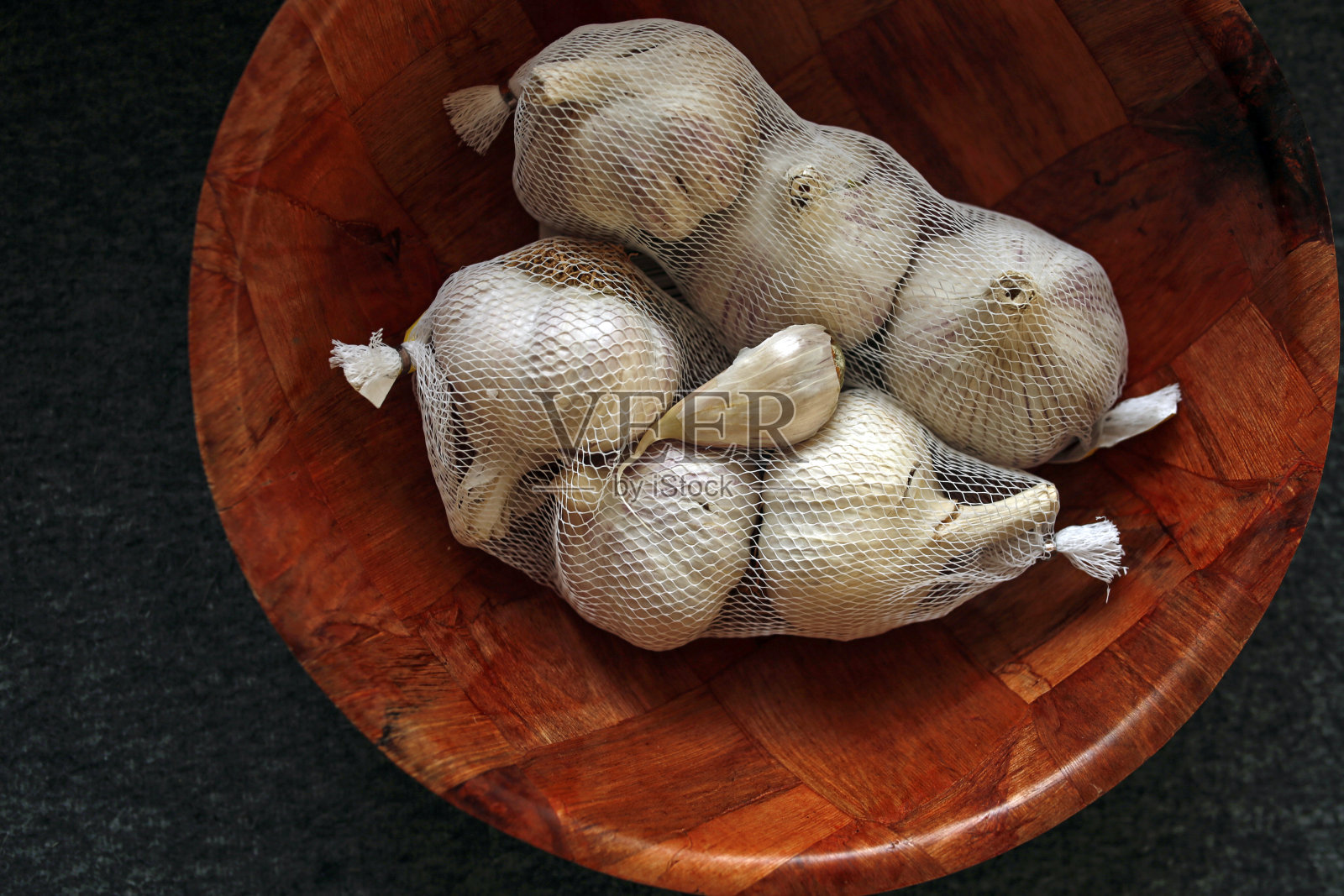 大蒜放在一个木碗里照片摄影图片
