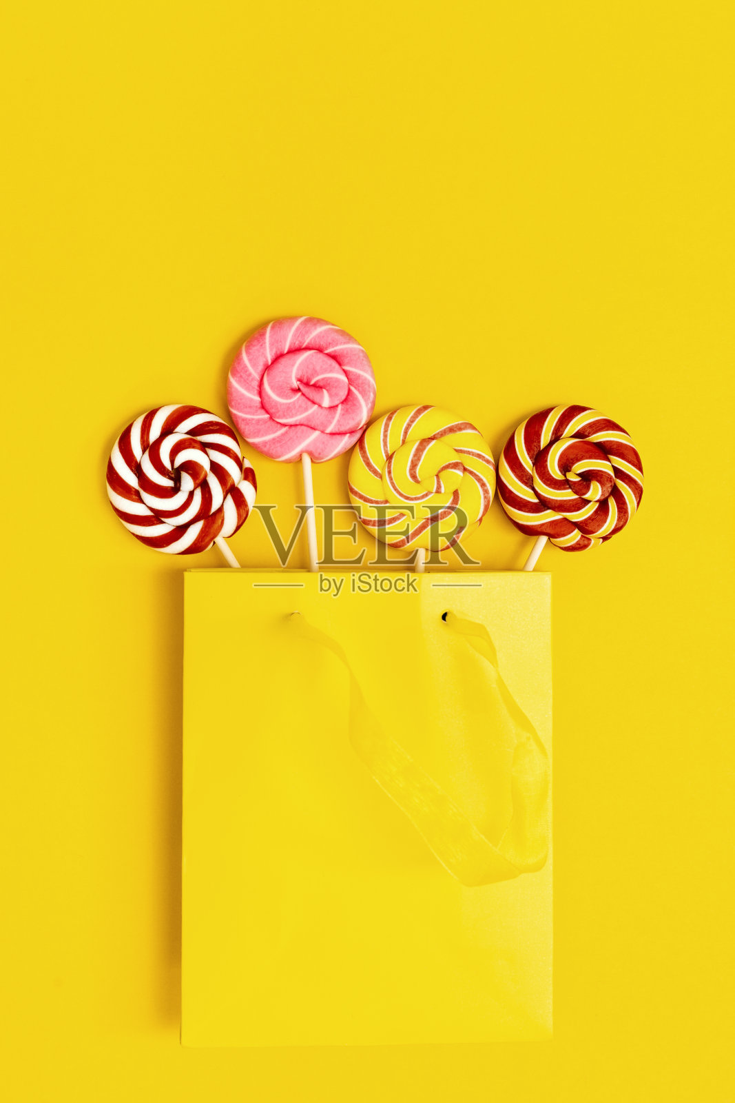 彩色棒棒糖糖果焦糖黄纸包装。明亮的背景明信片，或邀请生日，聚会，母鸡聚会。照片摄影图片