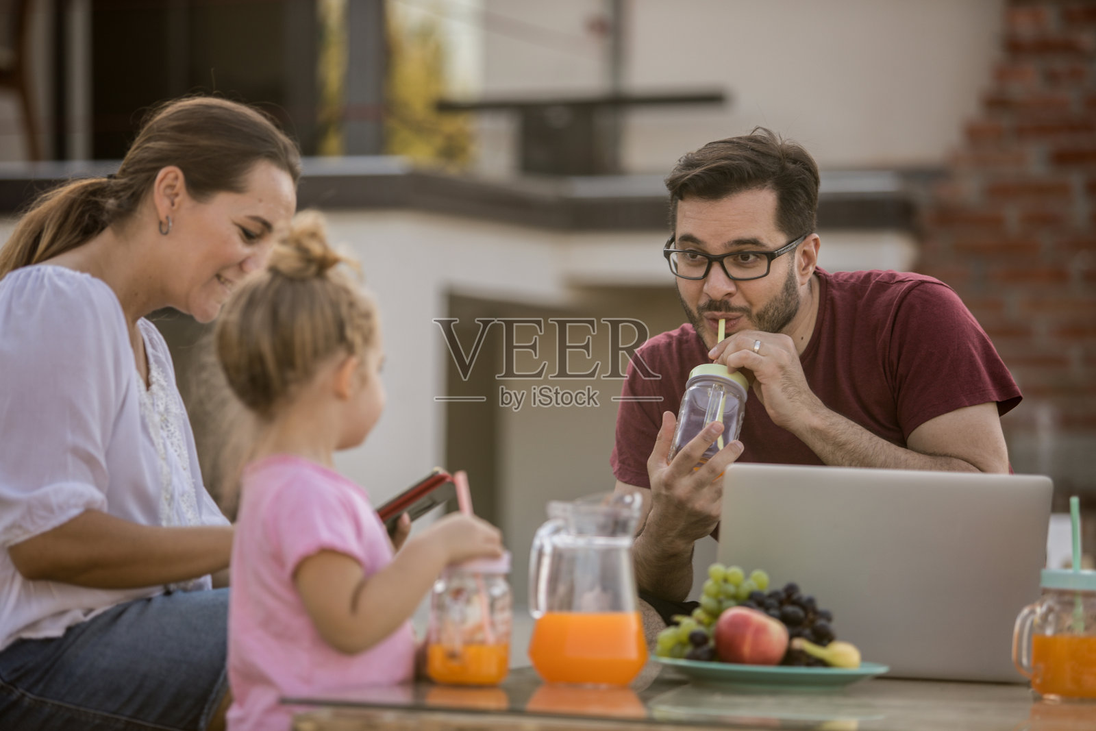 一家人在后院放松身心，享用清凉饮品照片摄影图片