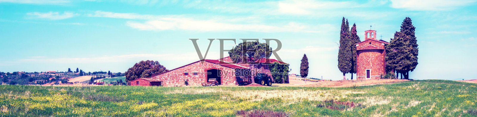 意大利托斯卡纳的圣基里科·奥西亚(Val d'Orcia)，一个阳光明媚的日子里，在油菜田附近的圣母教堂迷人的风景。优秀的旅游的地方。照片摄影图片