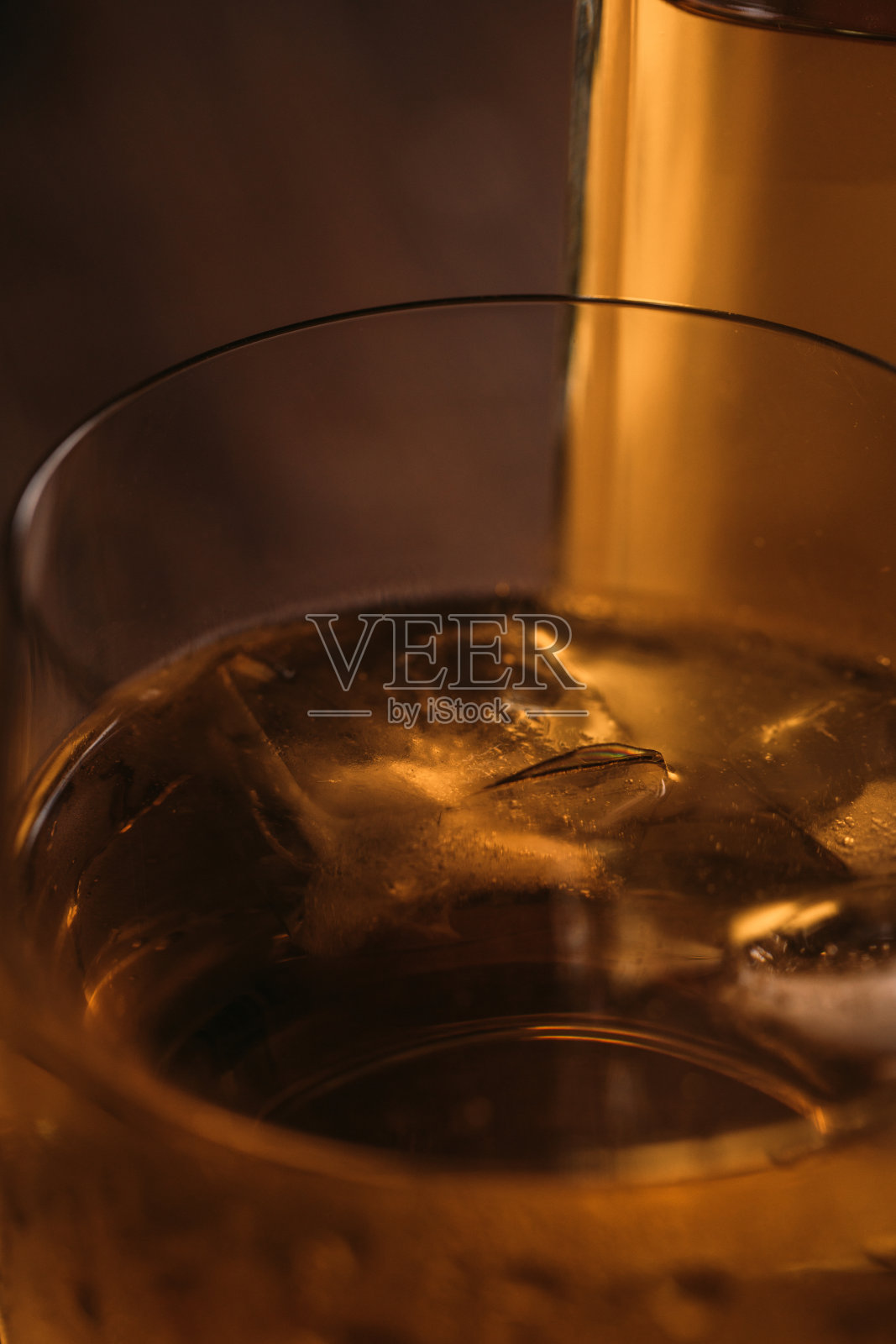 靠近在木桌上用玻璃杯盛着的苏格兰威士忌照片摄影图片