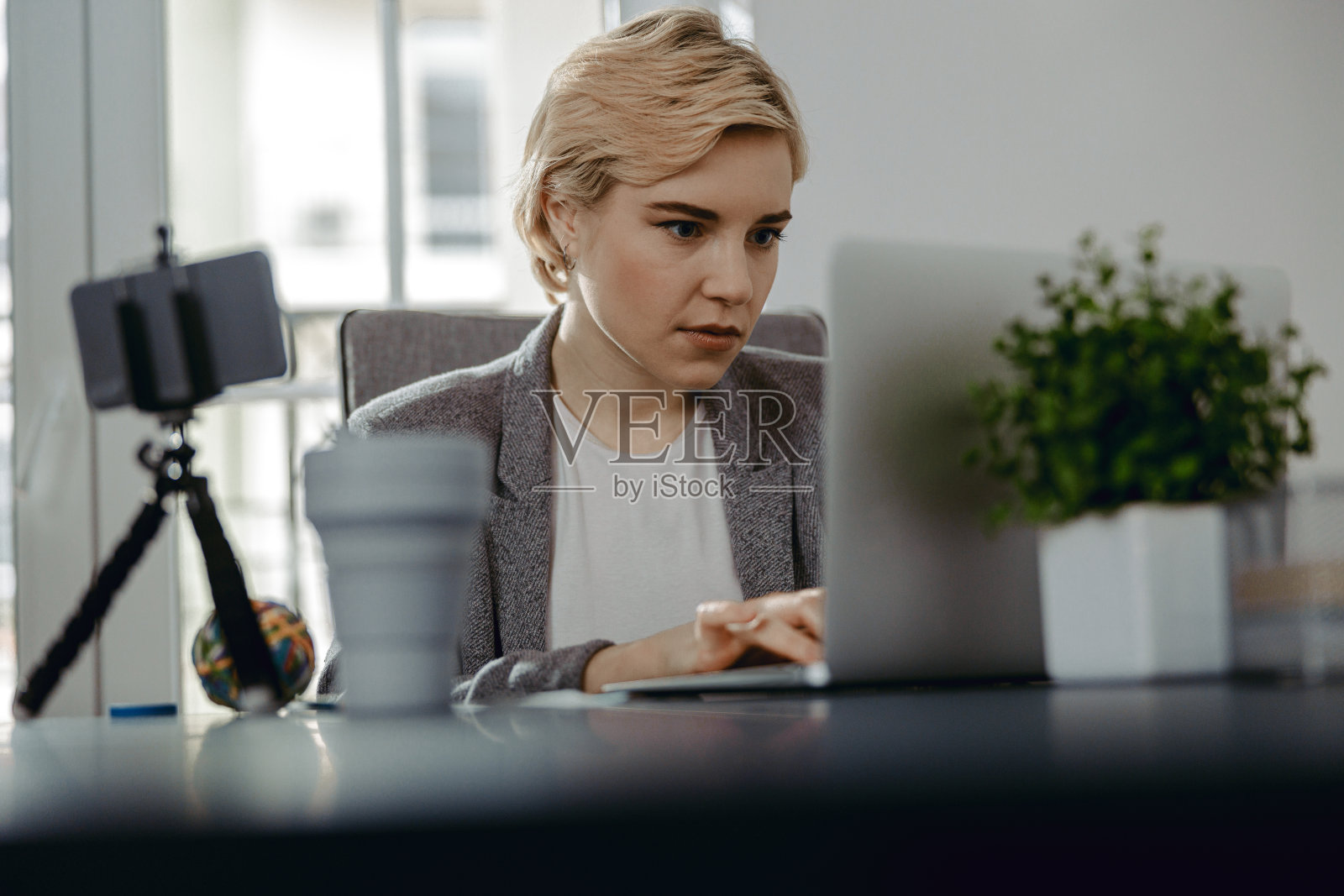 快乐的年轻女人在室内看笔记本电脑照片摄影图片