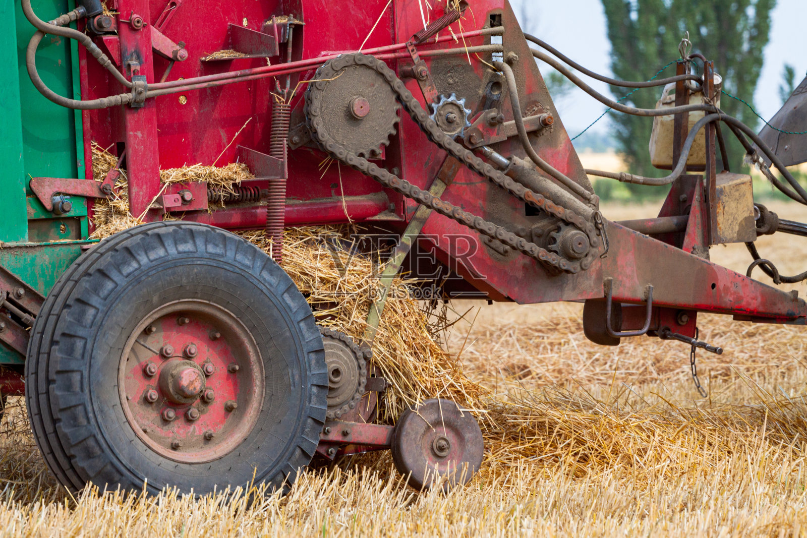 夏日里，拖拉机在黄色的田野上滚动着巨大的稻草照片摄影图片
