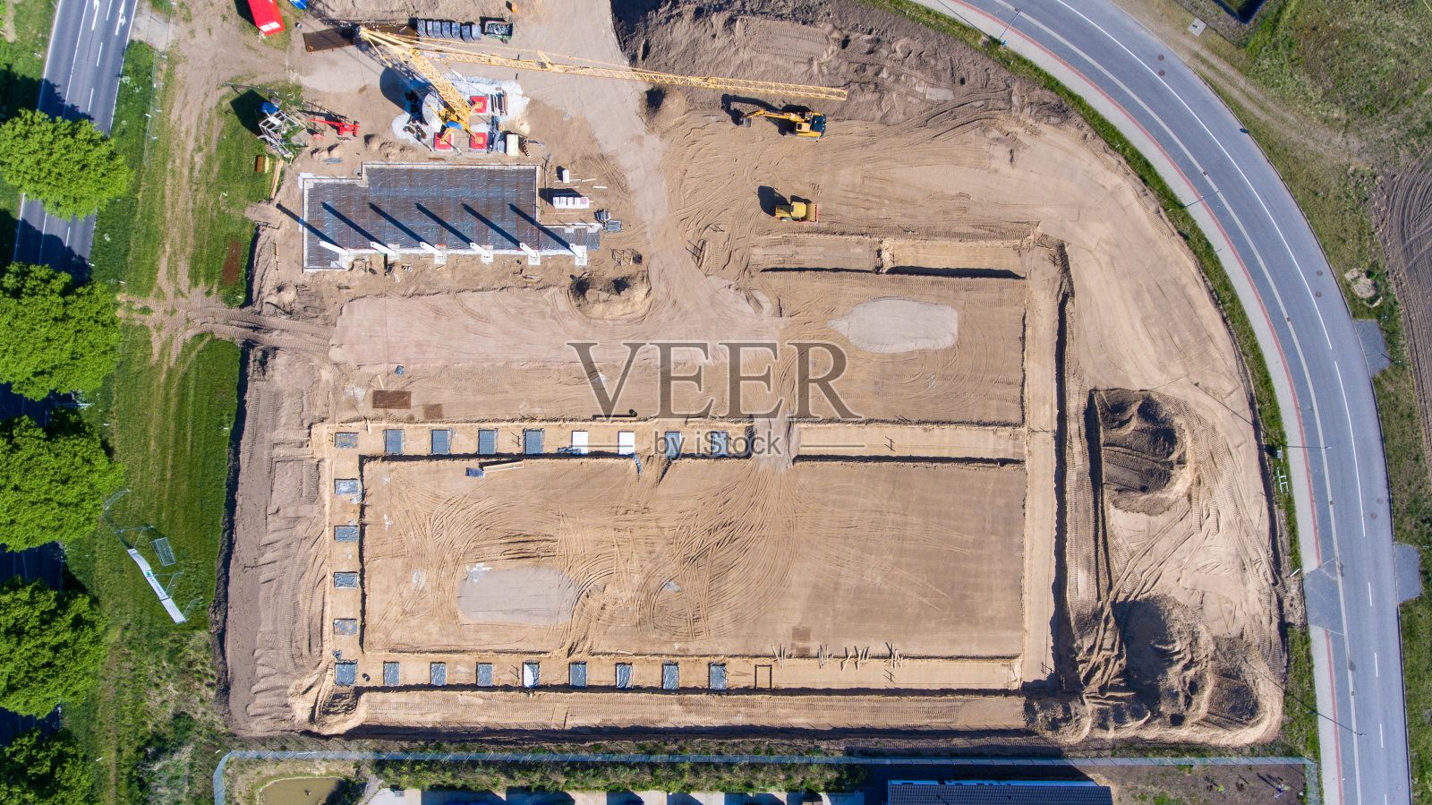 无人机拍摄的一处大型建筑工地上，一幢工厂大楼正在建造中。桥墩的基础已经奠定，第一个桥墩也已经竖起照片摄影图片