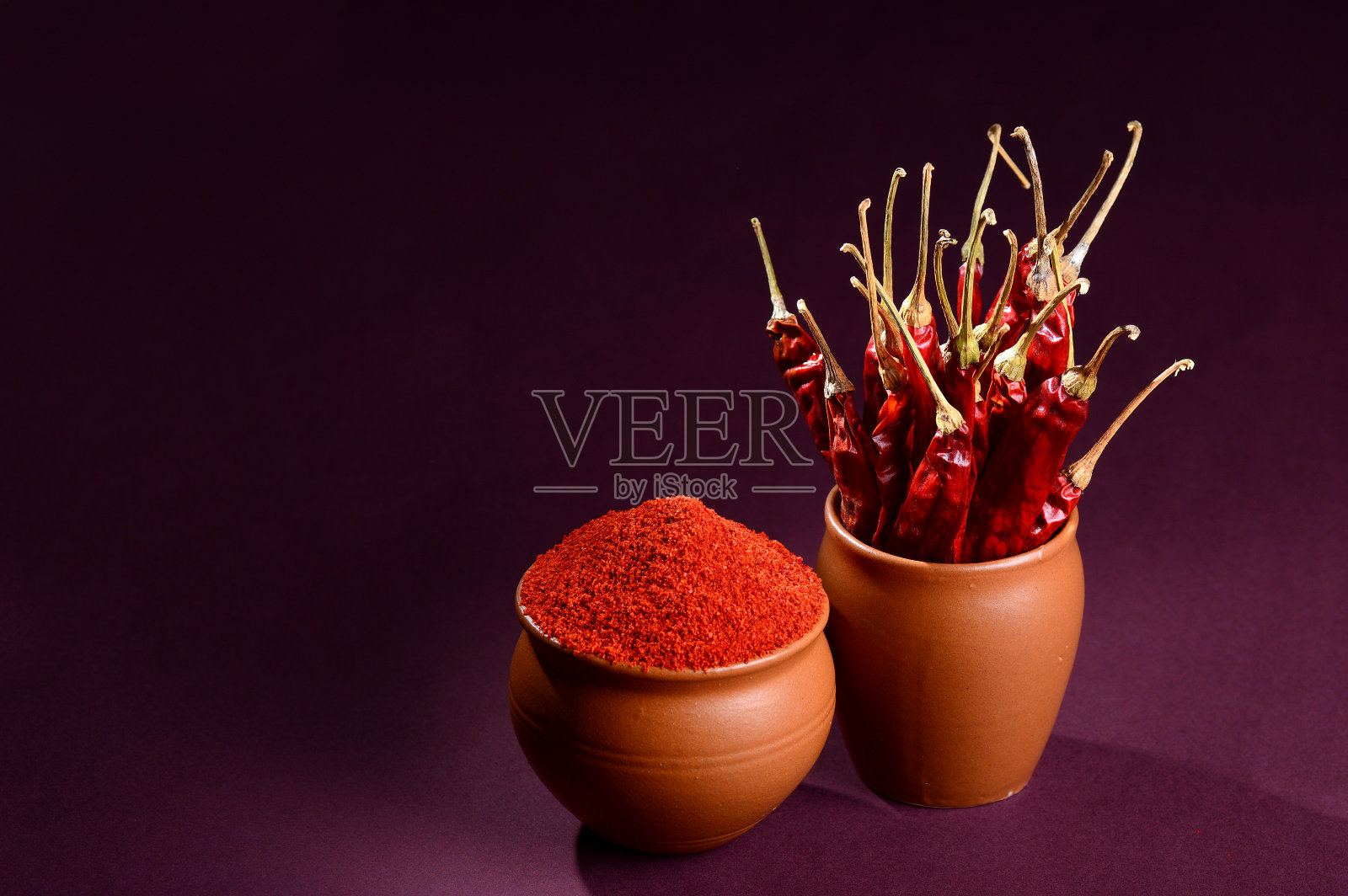 凉粉与红色凉粉在陶罐，干辣椒在黑暗的背景照片摄影图片