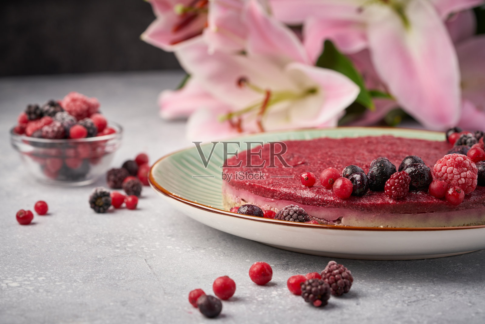 生纯素浆果樱桃芝士蛋糕无麸质灰色背景。照片摄影图片