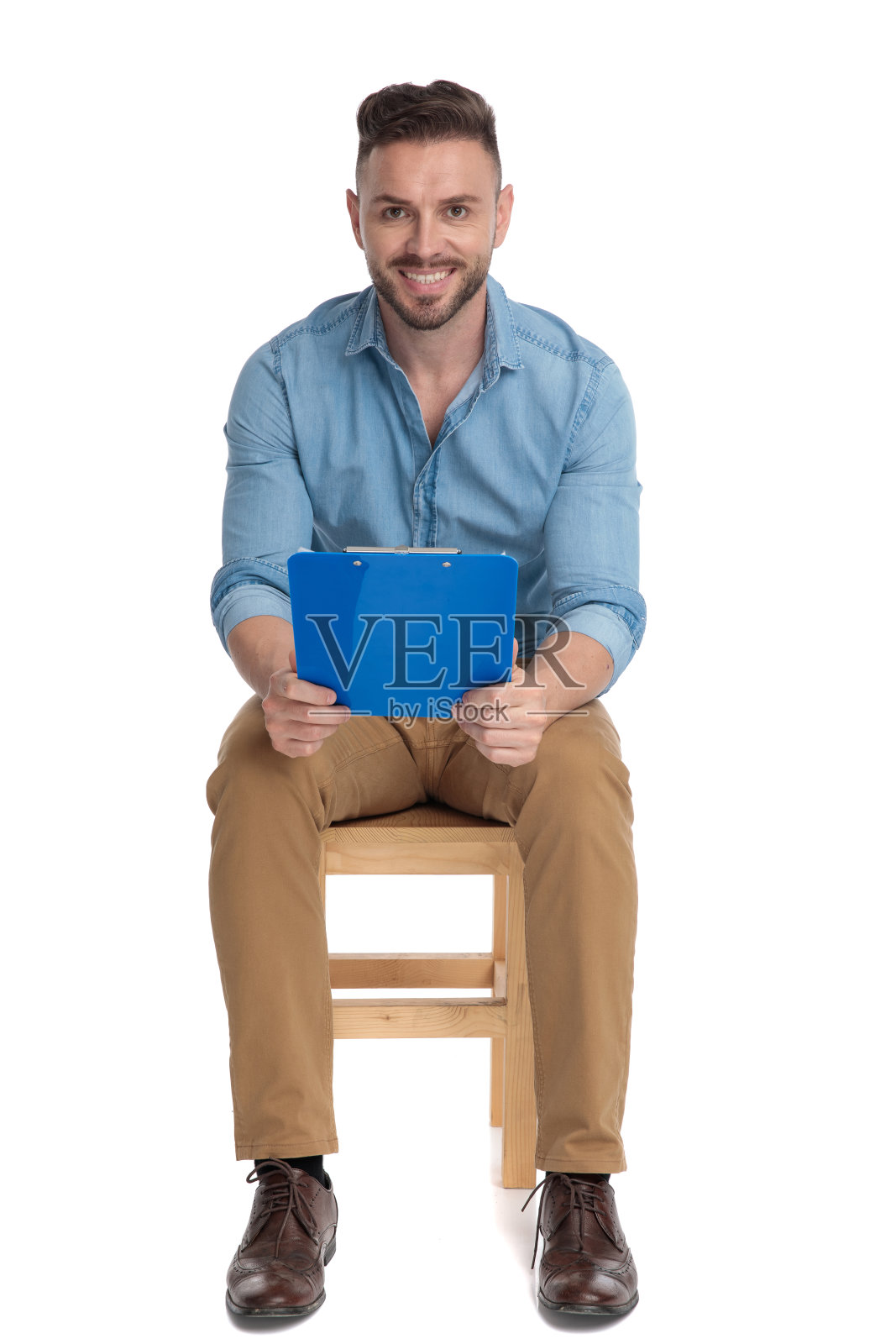 快乐的年轻男子拿着剪贴板微笑照片摄影图片