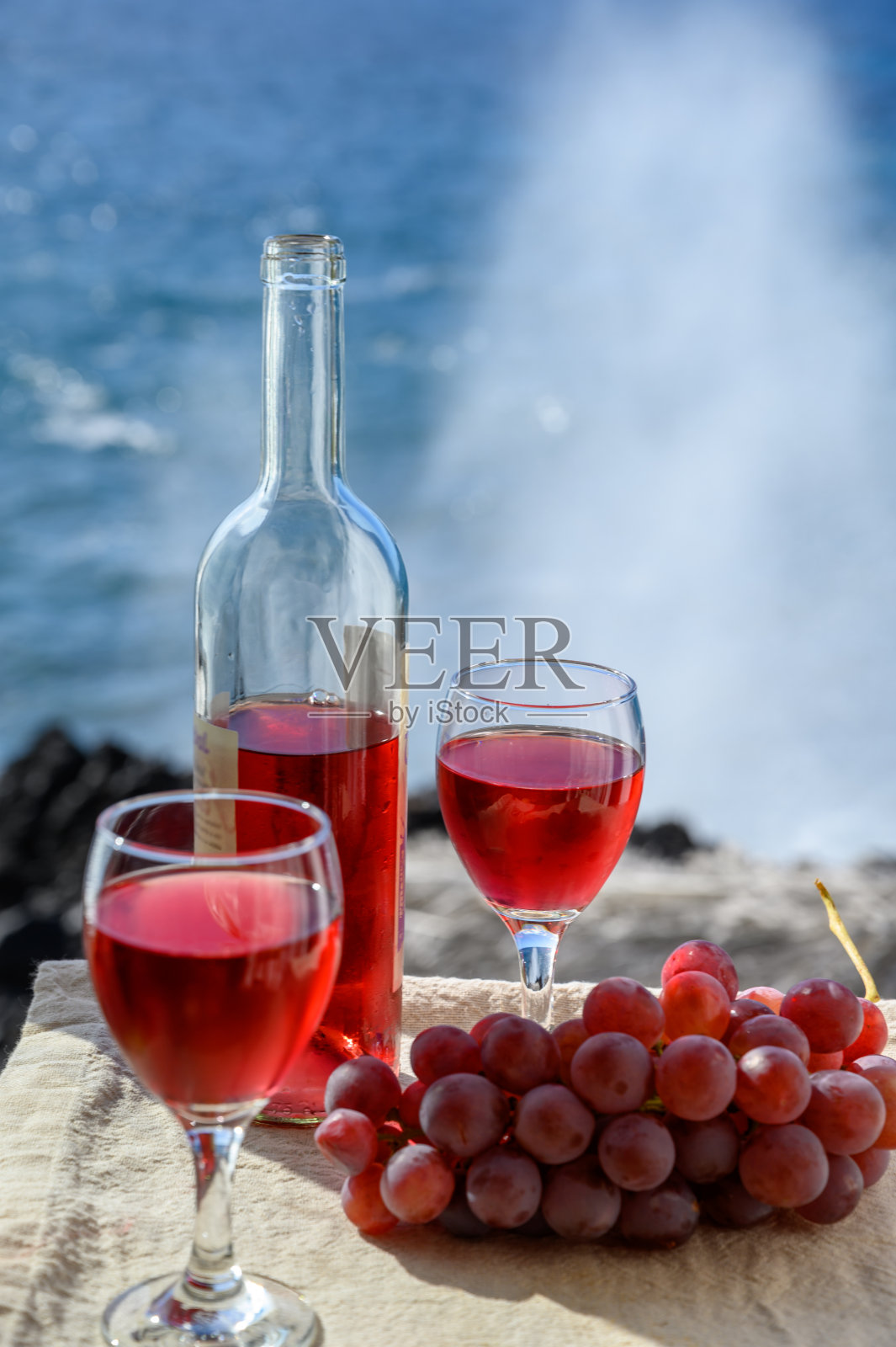 在热带岛屿拉帕尔马，加那利群岛，西班牙美丽的蓝色海景，两杯玫瑰葡萄酒与粉红色的葡萄水果户外供应照片摄影图片