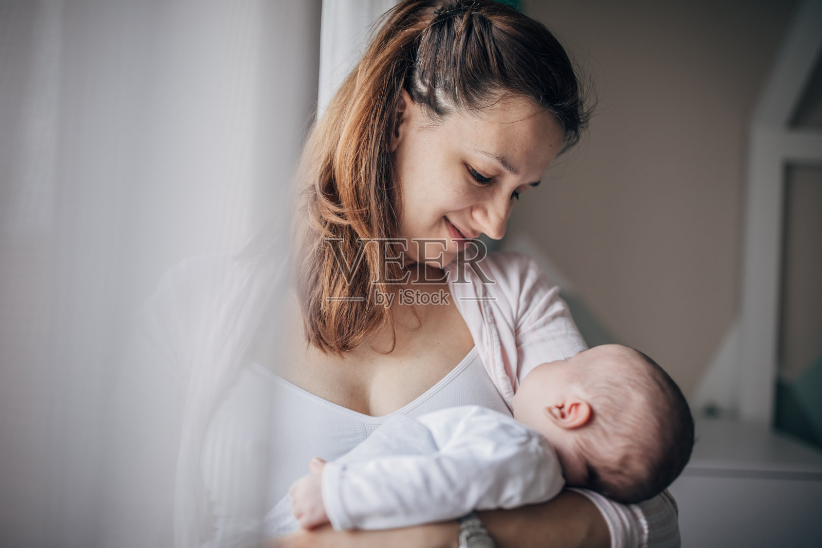 母亲在家中怀抱男婴照片摄影图片