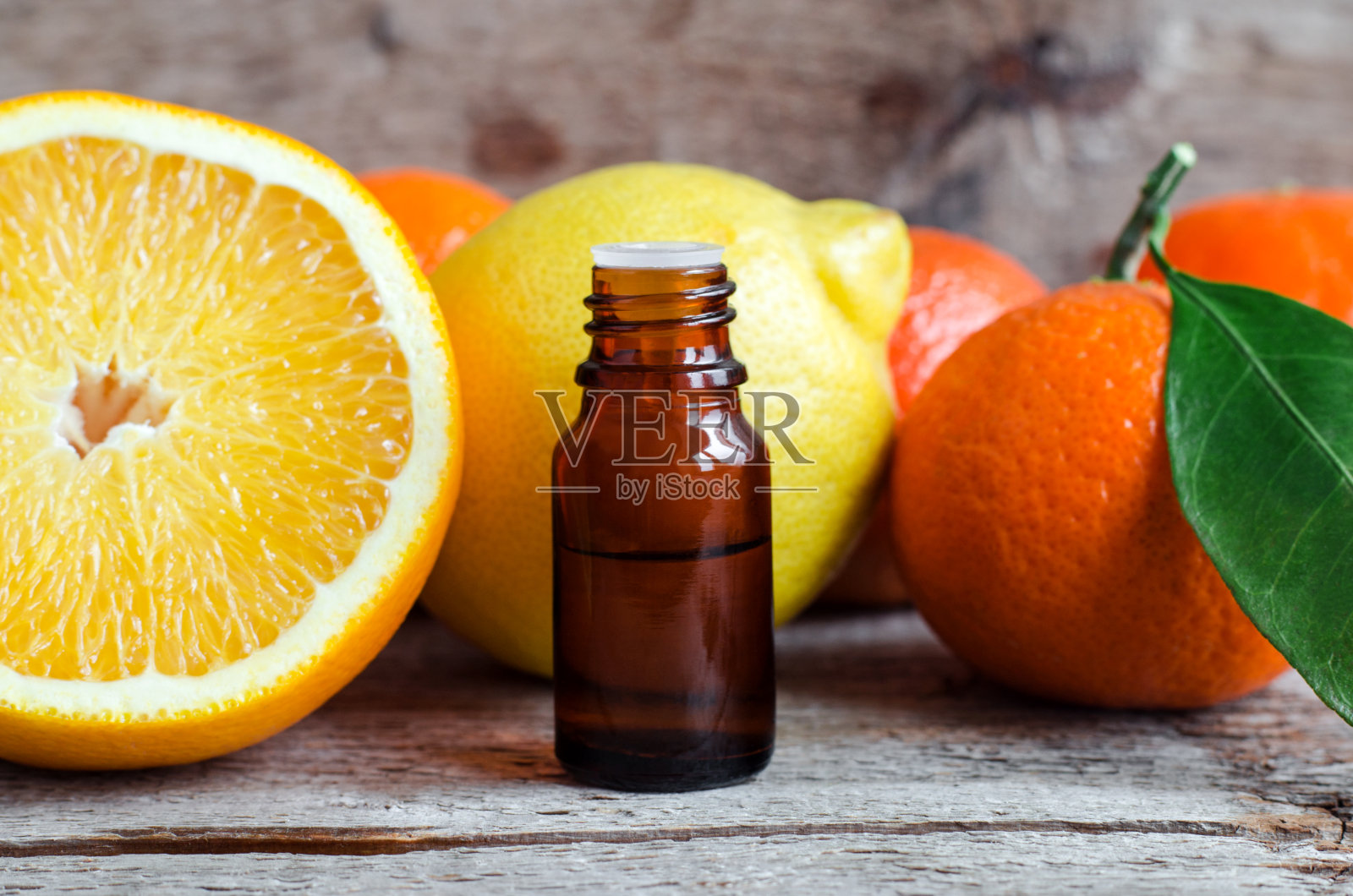 小瓶柑橘精油(提取物，酊剂，浸剂，香水)。芳香疗法，水疗和草药成分。老木的背景。本空间照片摄影图片