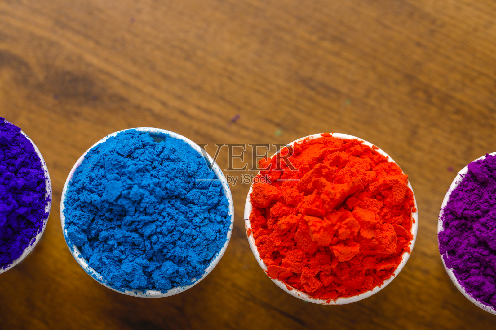 印度胡里节，杯子的颜色在木制背景上照片摄影图片