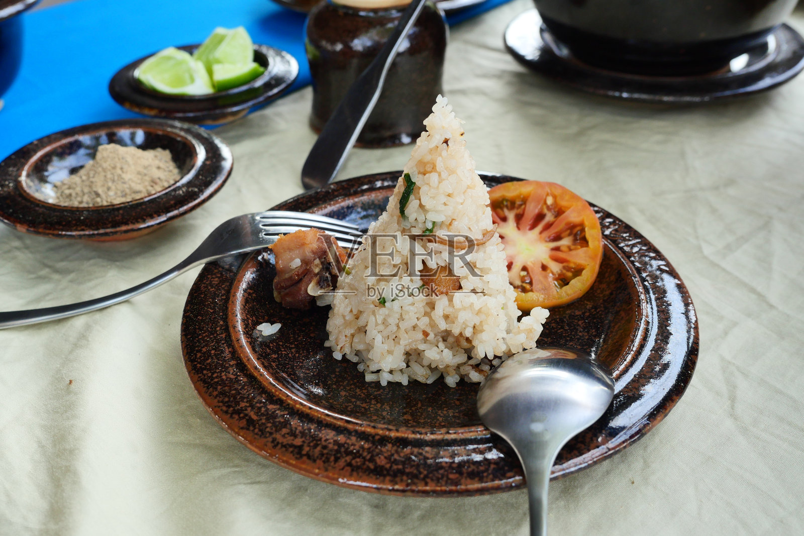 粽子或传统的中国糯米饺子和切片的西红柿在棕色的盘子照片摄影图片