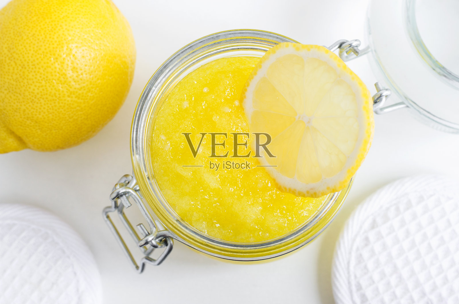 自制柠檬面膜(糖磨砂膏)放在玻璃罐里。DIY美容和水疗配方。俯视图，复制空间。照片摄影图片