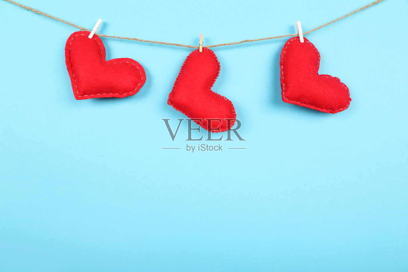 蓝色背景上挂着衣夹的布心照片摄影图片