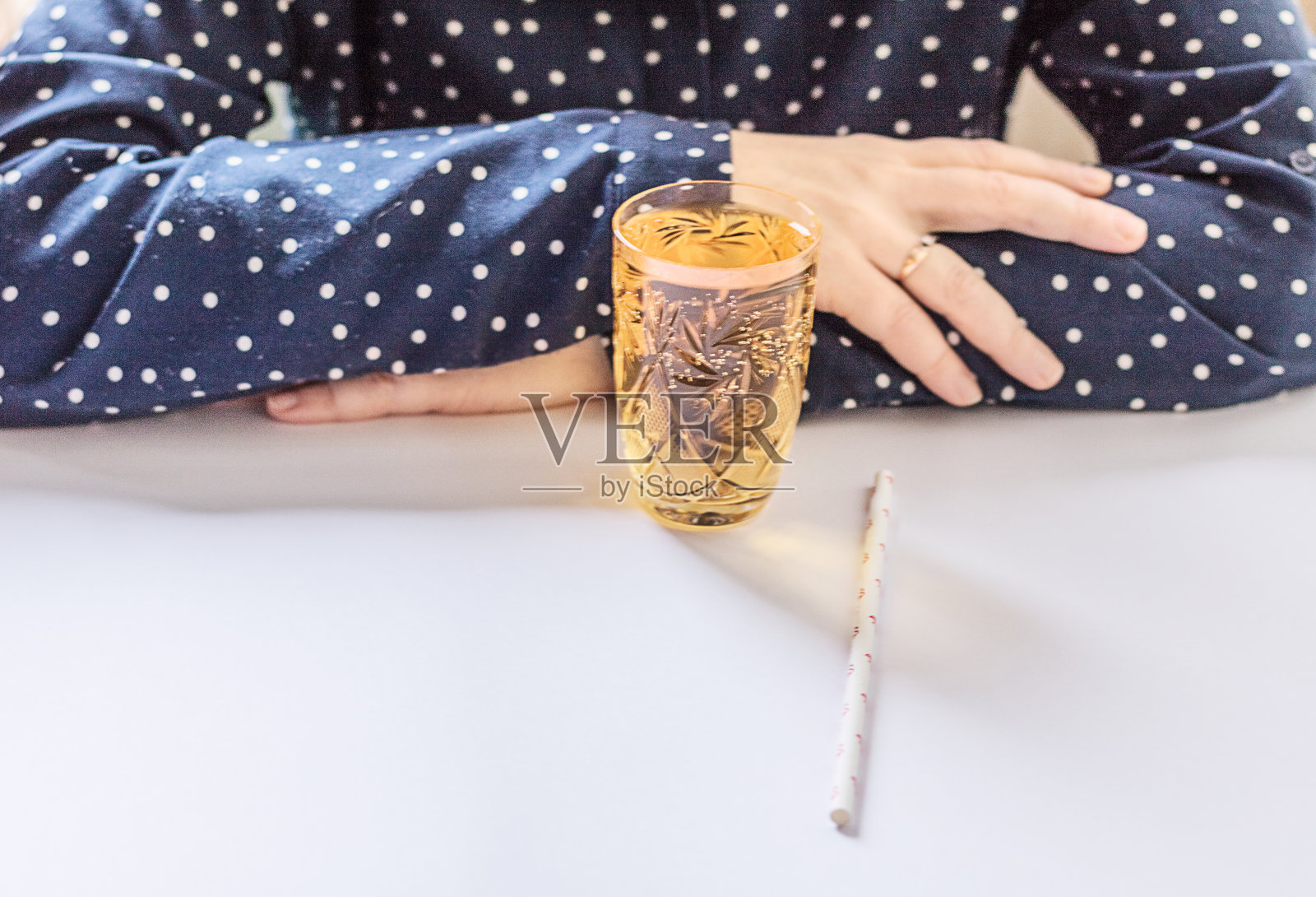 桌子前女孩手中的鲜榨苹果汁照片摄影图片