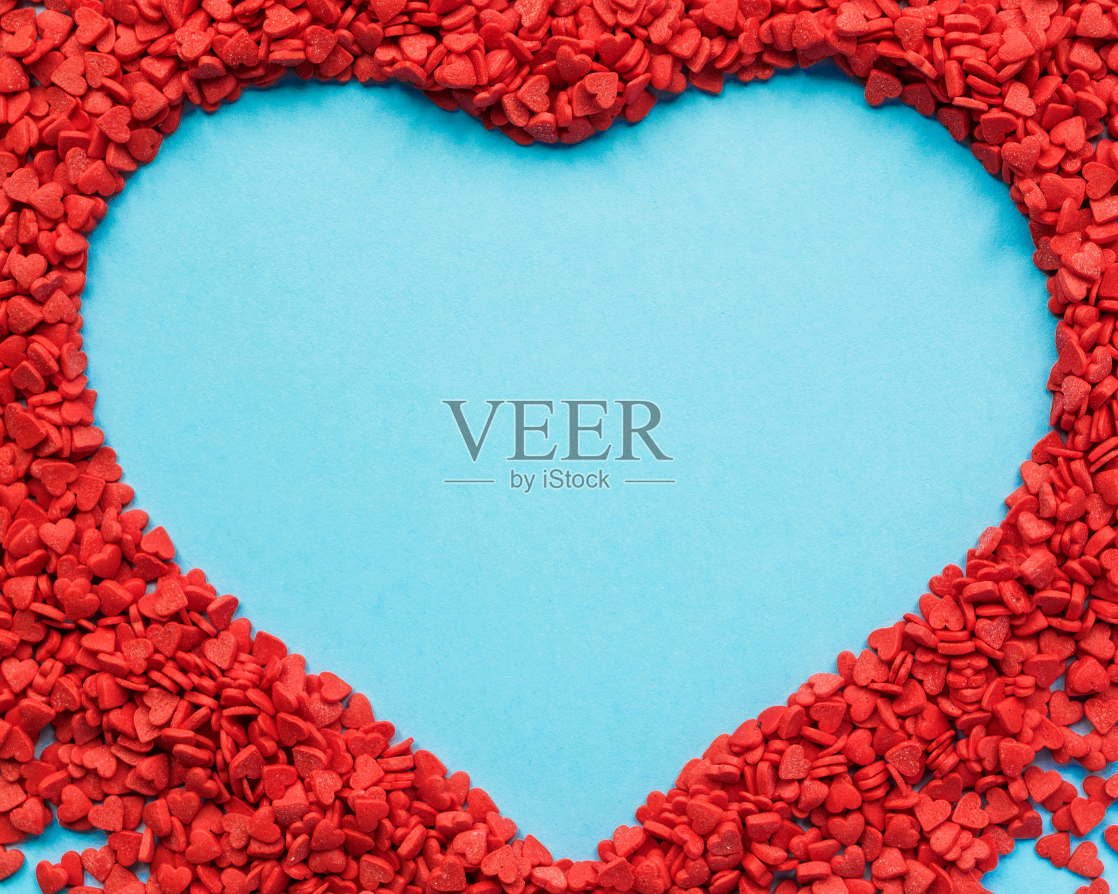 许多小心形在蓝色背景上折叠成一个大心形。心为情人节与拷贝空间。2月14日的模板照片摄影图片