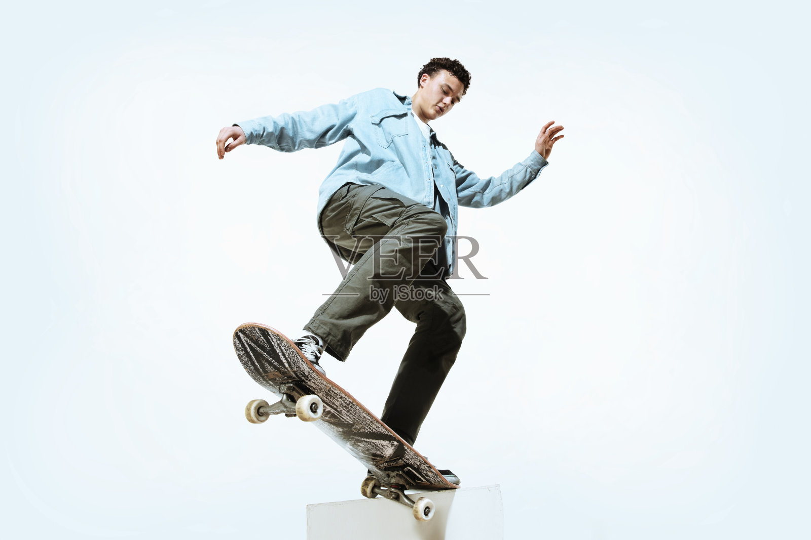 白人年轻的滑板手骑在一个孤立的白色背景照片摄影图片