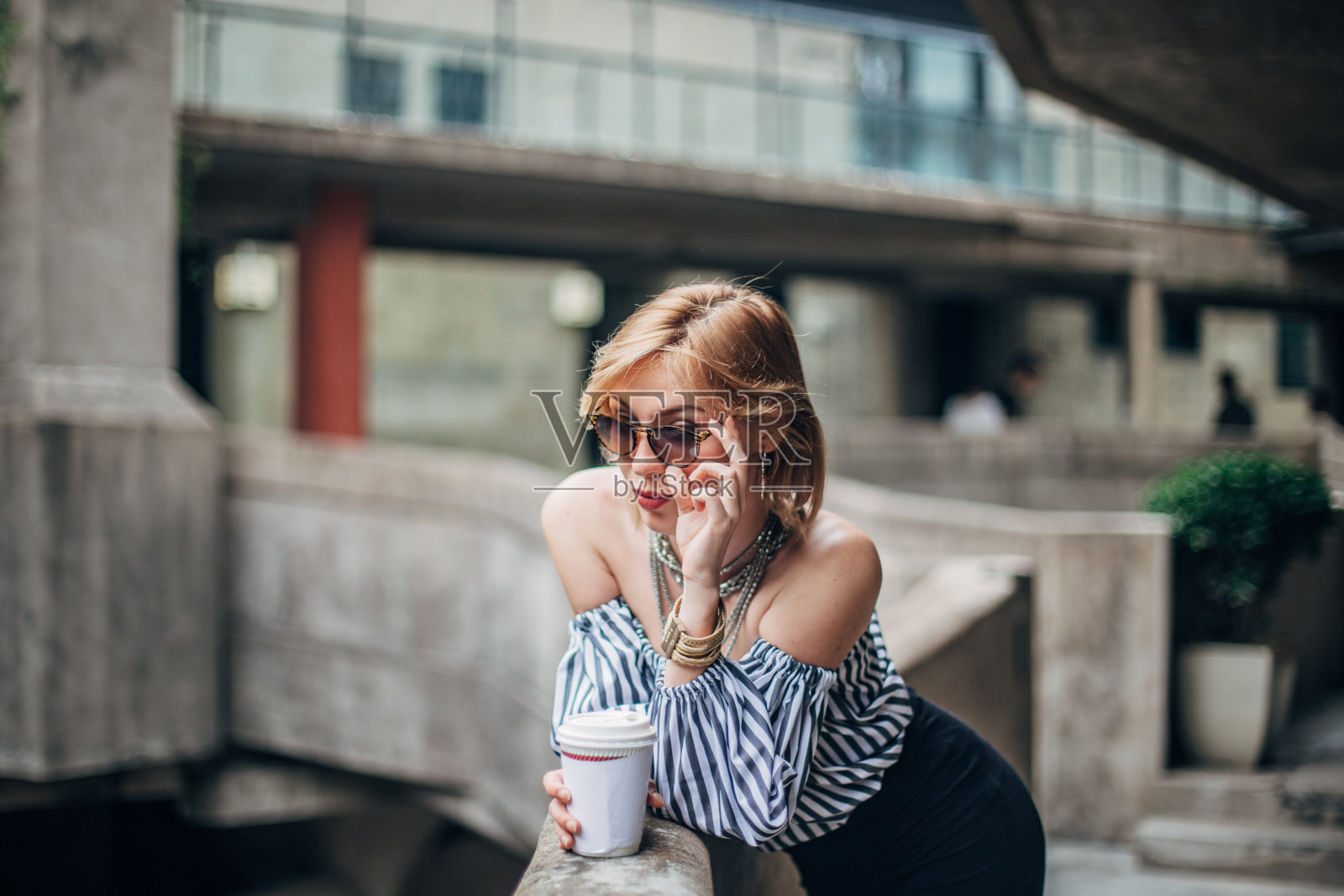 城里的年轻女子，拿着咖啡杯照片摄影图片
