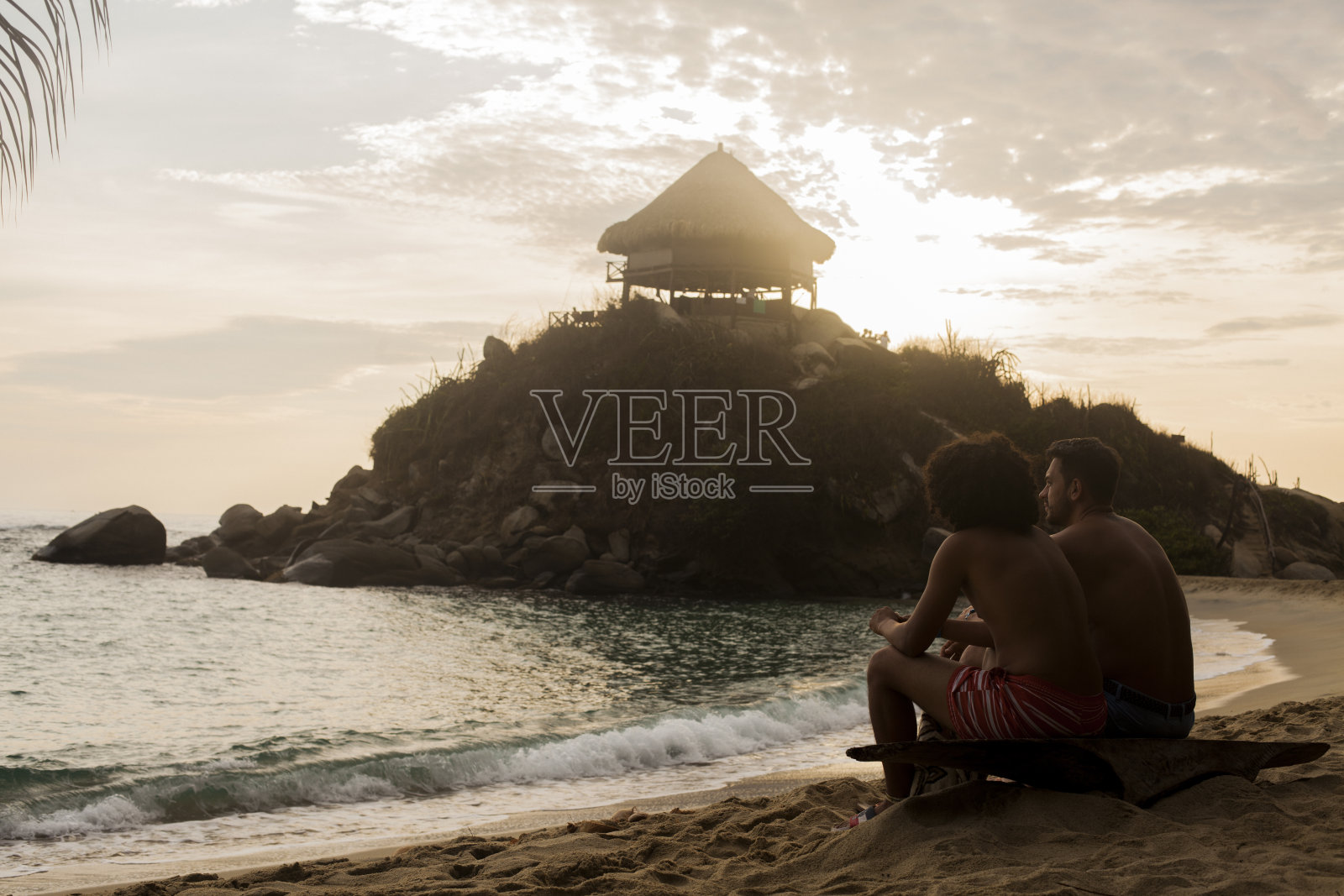 一群朋友坐在海滩前照片摄影图片