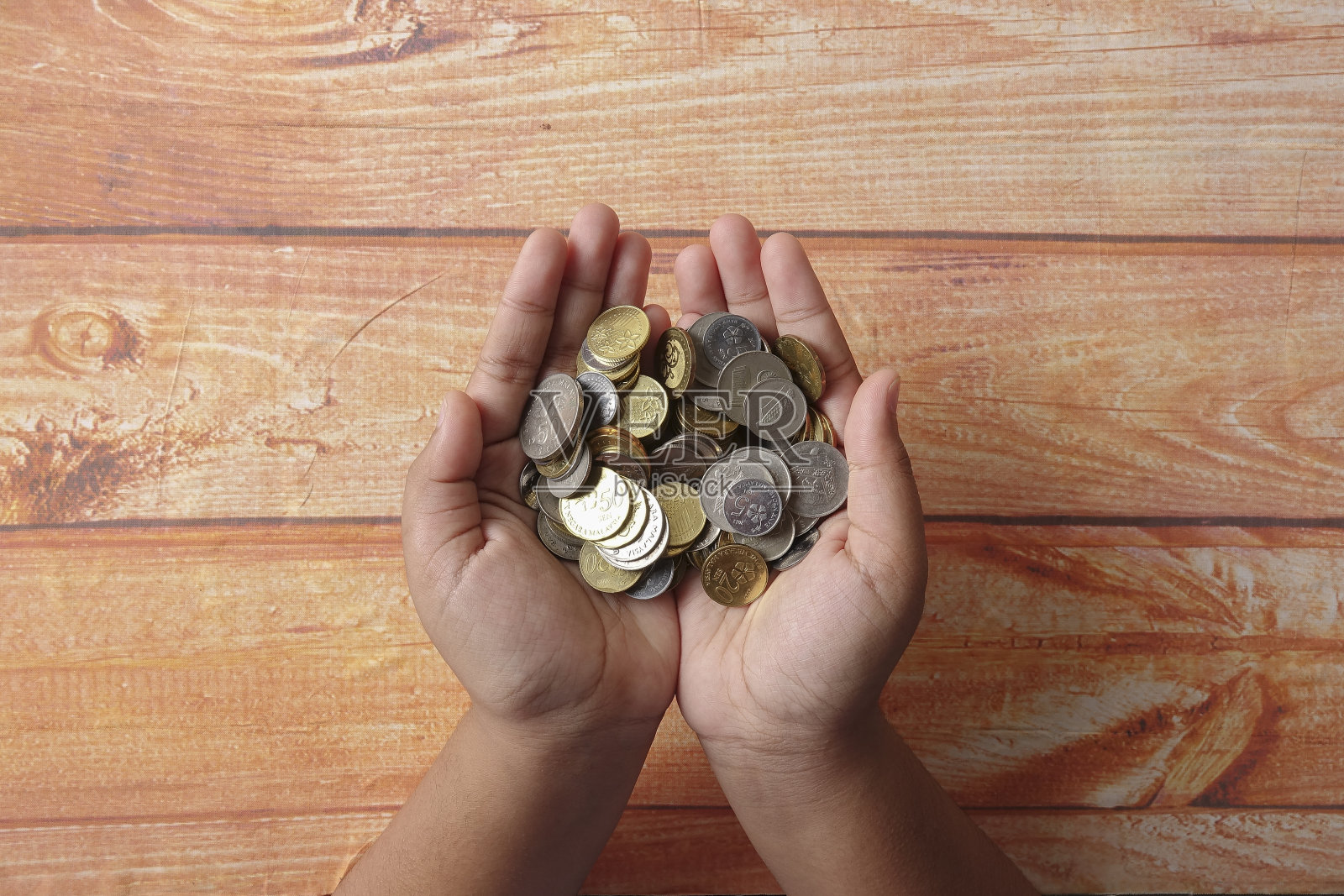 手掌小孩手里握着一把硬币照片摄影图片