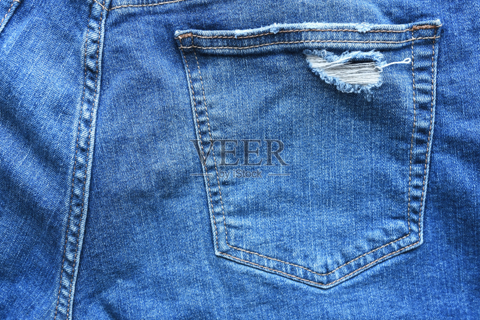 破牛仔裤的口袋里照片摄影图片