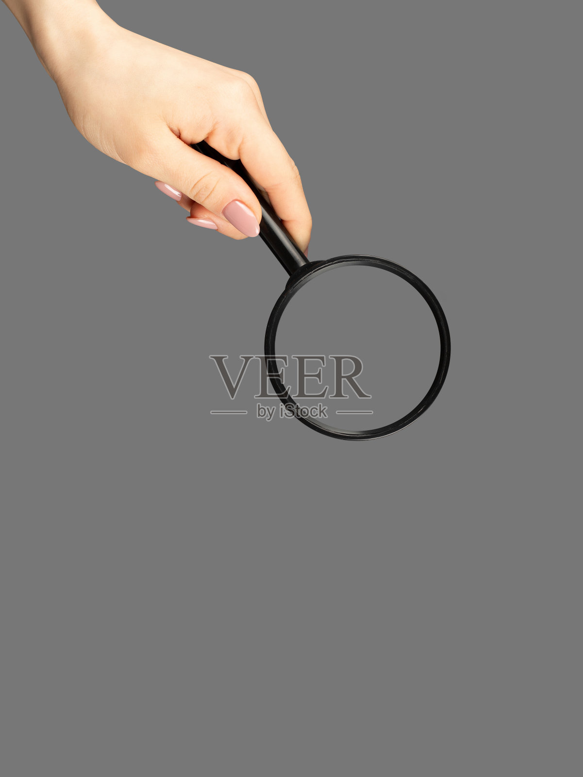 手持放大镜在灰色背景照片摄影图片