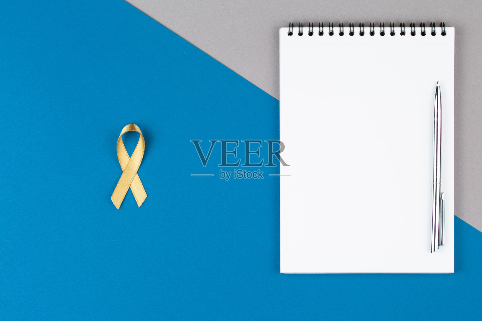 蓝色背景的打开笔记本上的金色丝带照片摄影图片