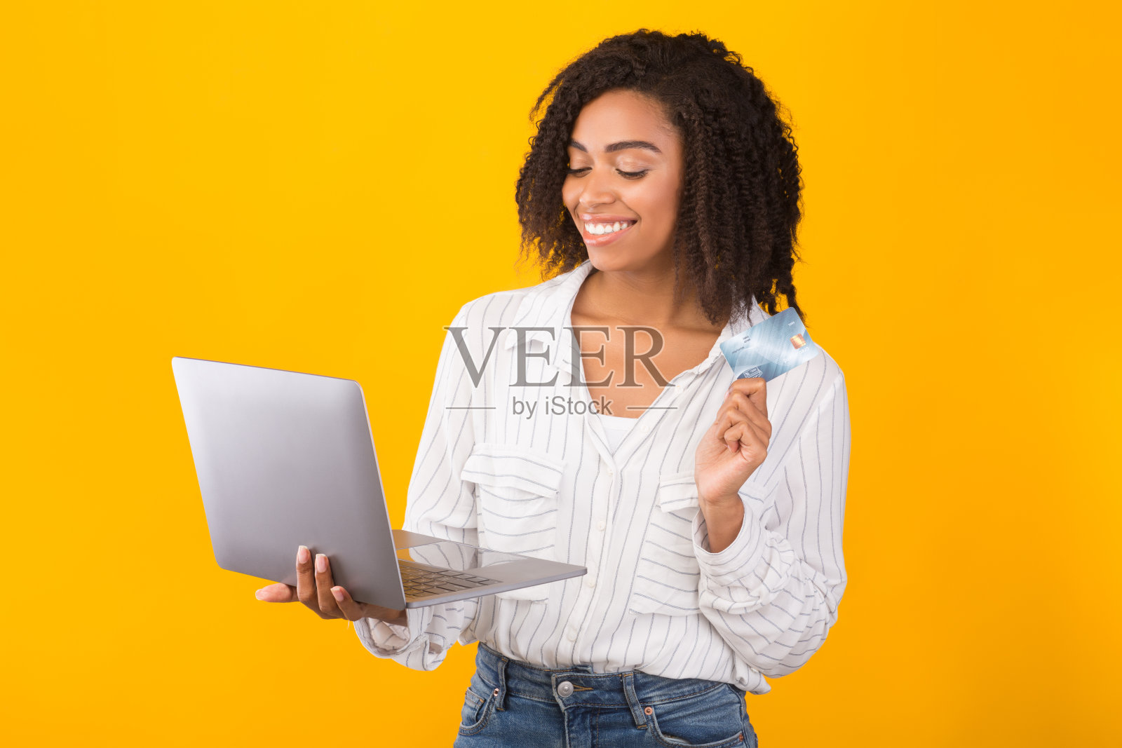 微笑的非洲女人拿着卡片和电脑照片摄影图片