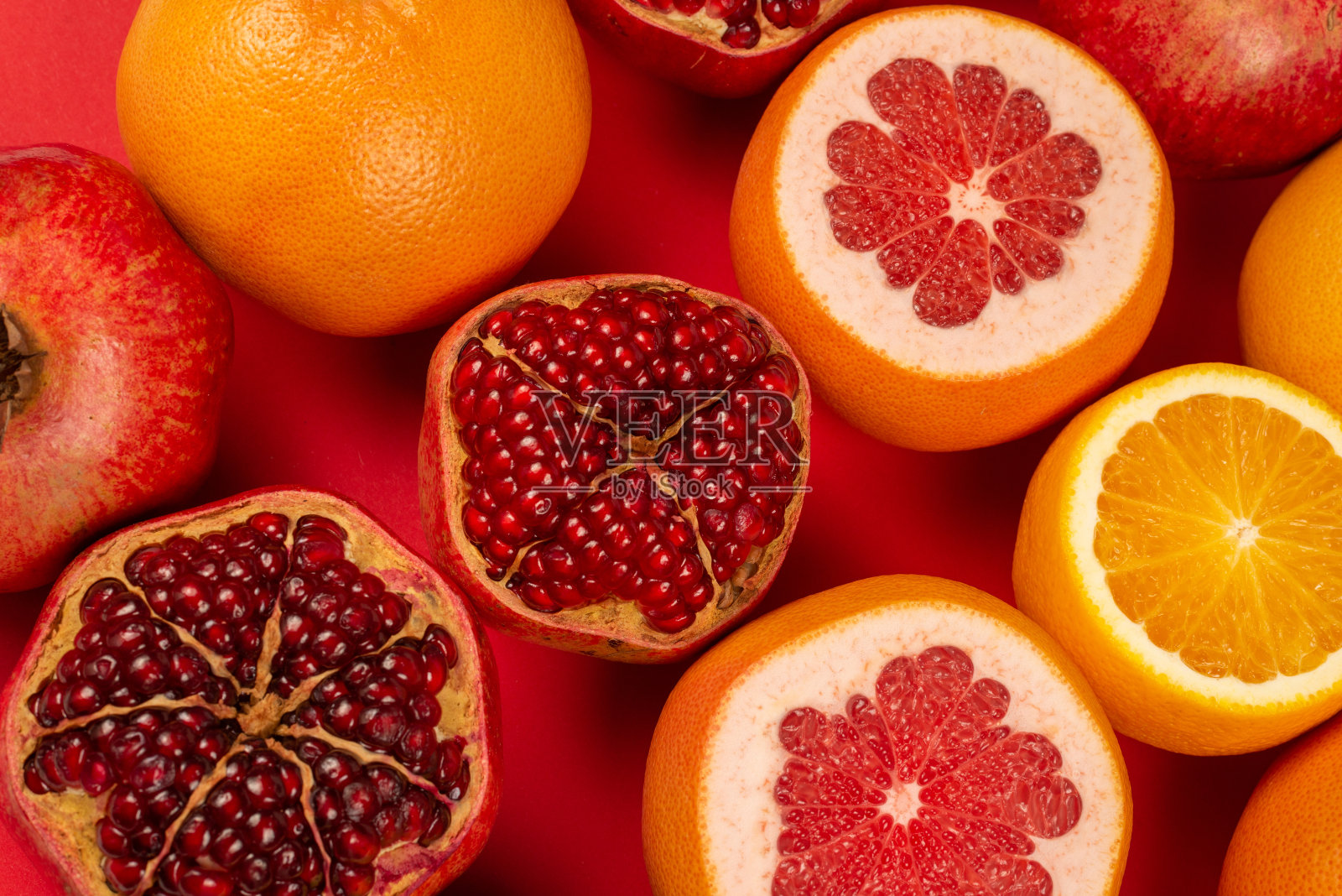 柚子，橙子，石榴，柑橘甜在红色的背景。照片摄影图片