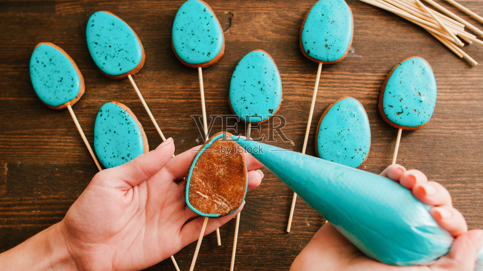 复活节烹饪妇女给蛋形饼干上釉照片摄影图片
