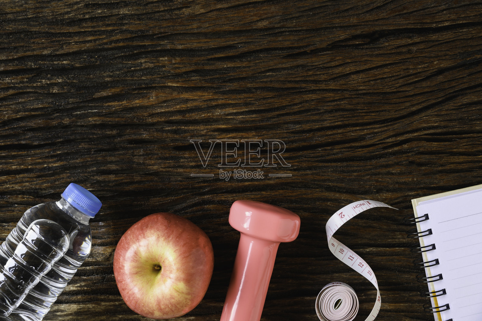 俯视图健康物体上的旧木制哑铃，水和耳机的运动或运动的概念。照片摄影图片