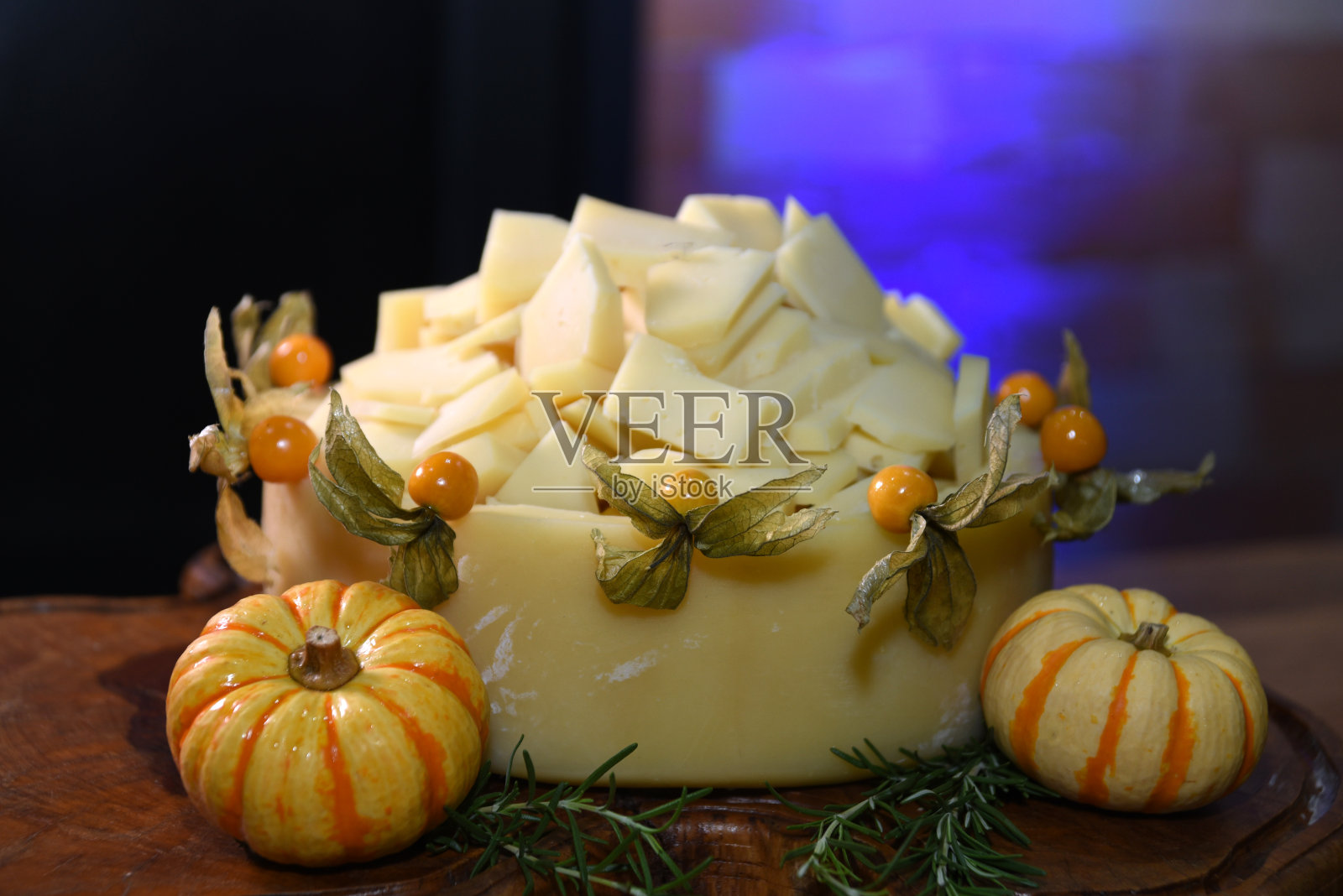 奶酪和小南瓜放在木桌上，配上香草和胡椒照片摄影图片